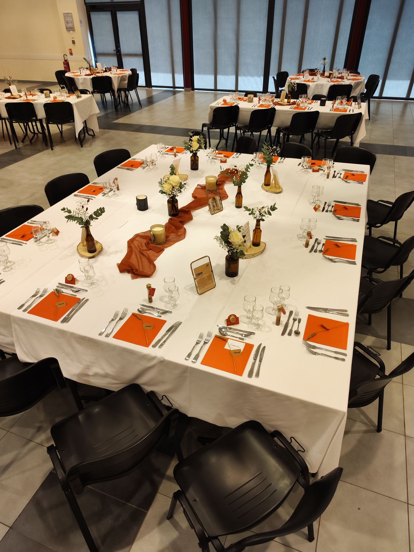 Mariage Espace Galerne table blanche hemin de table terracotta rondin en bois composition florale serviette orange bougie