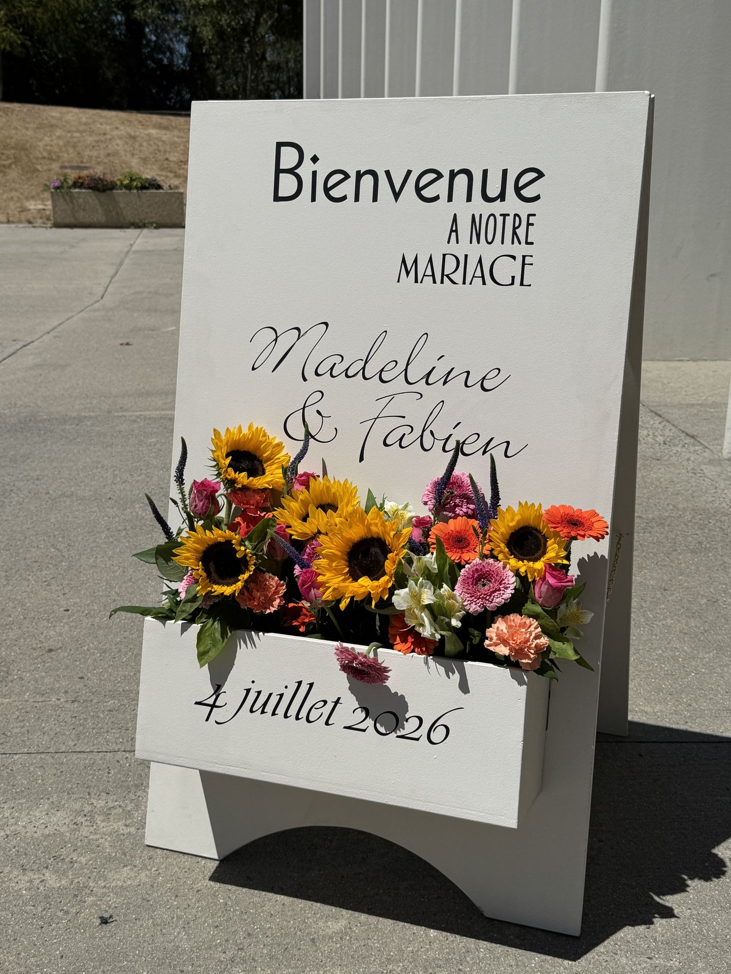 panneau de bienvenu blanc et jardin de fleurs coloré
