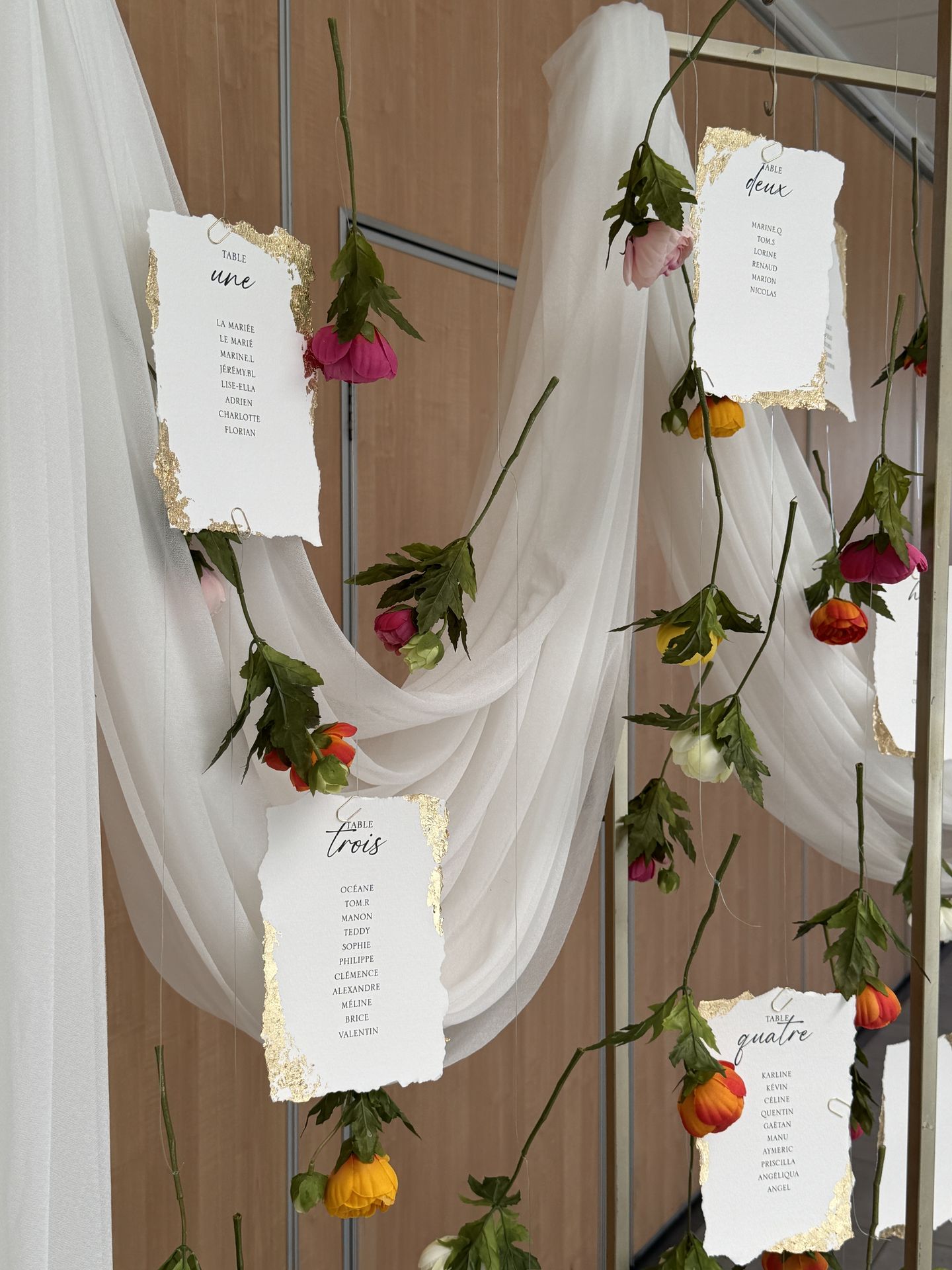 plan de table doré drapé blanc fleurs tombantes et nom de table feuille doré