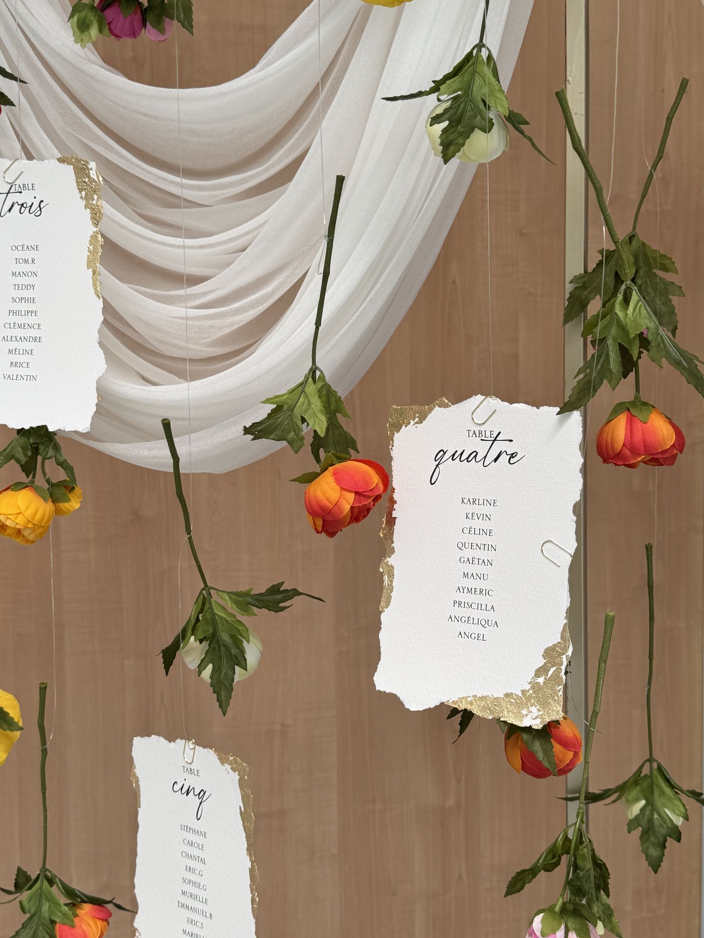 plan de table doré drapé blanc fleurs tombantes et nom de table feuille doré