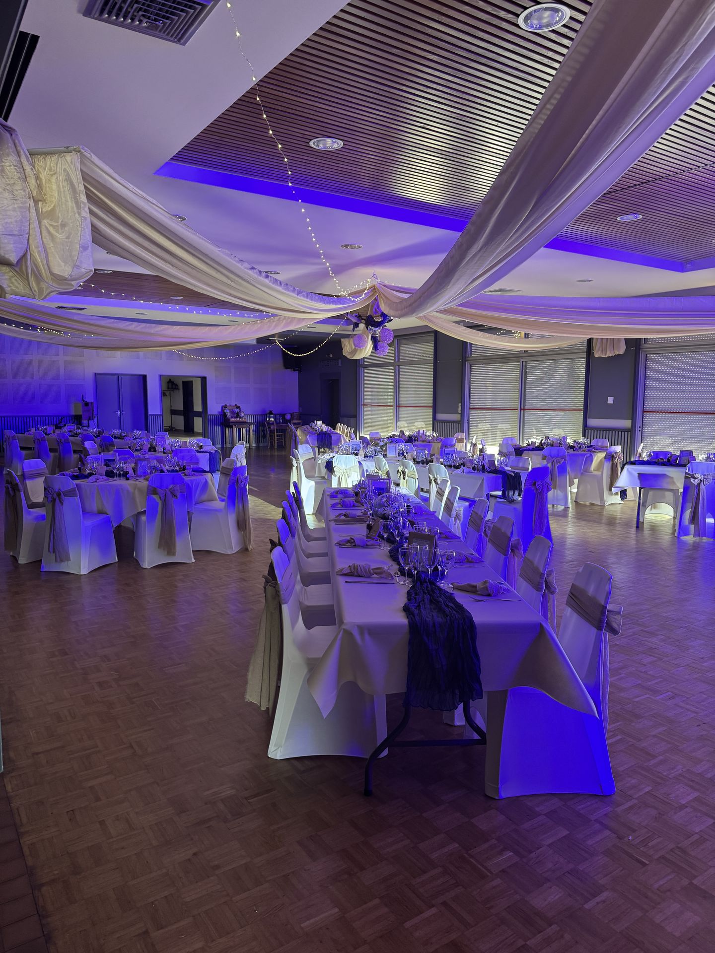 salle intérieur plafond tentures sable et led table blanche et chemin de table bleu
