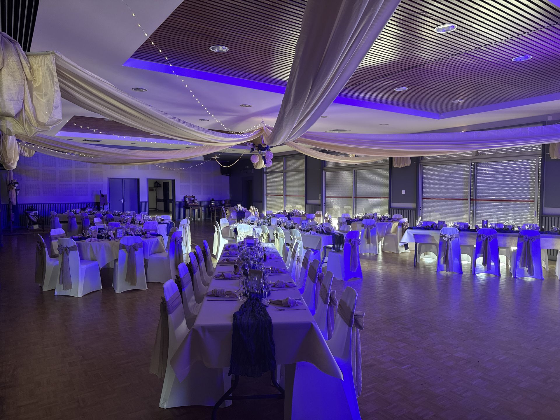 salle intérieur plafond tentures sable et led table blanche et chemin de table bleu