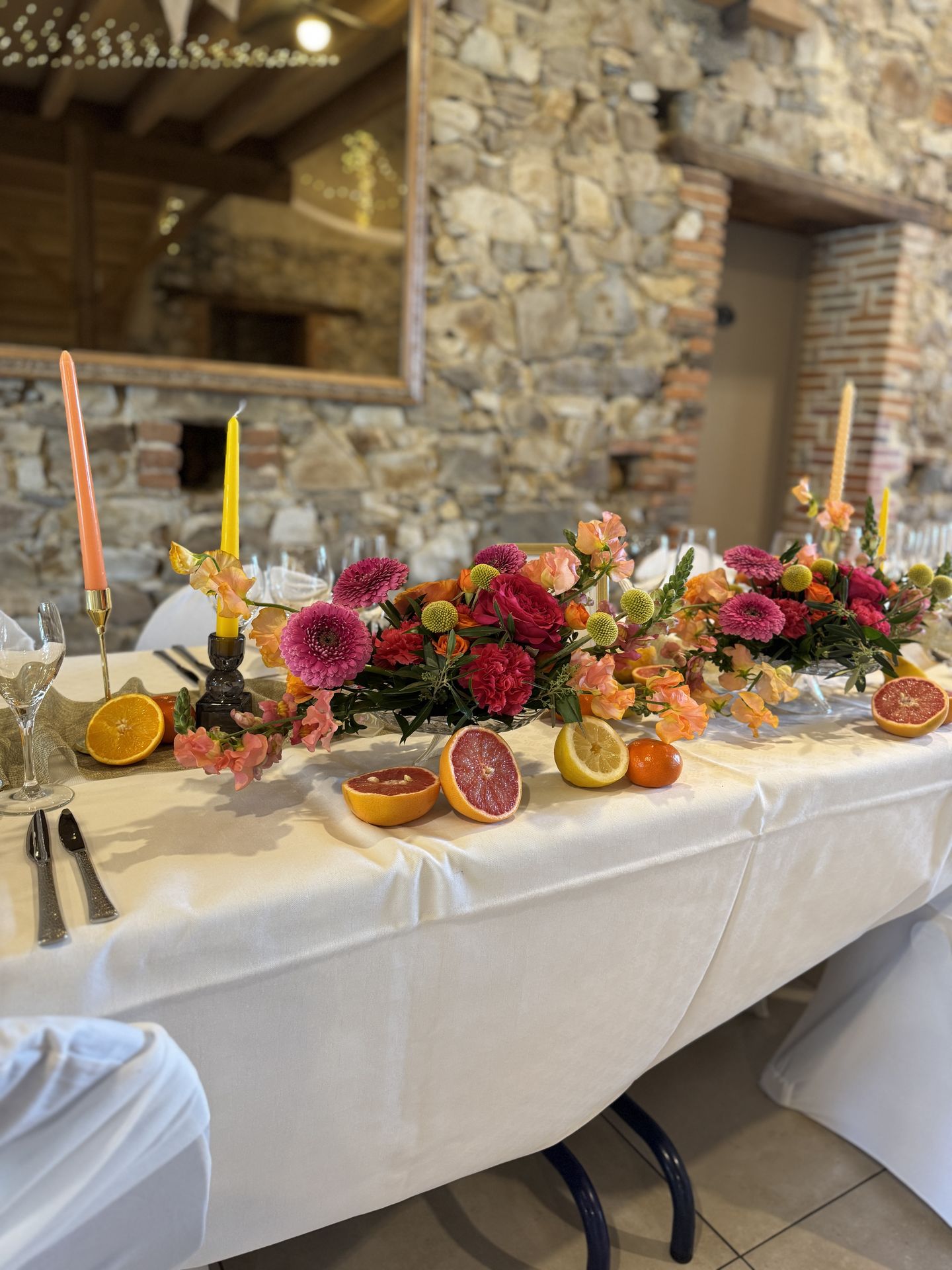 table d'honneur composition florales coloré et agrumes bougies chandeliers