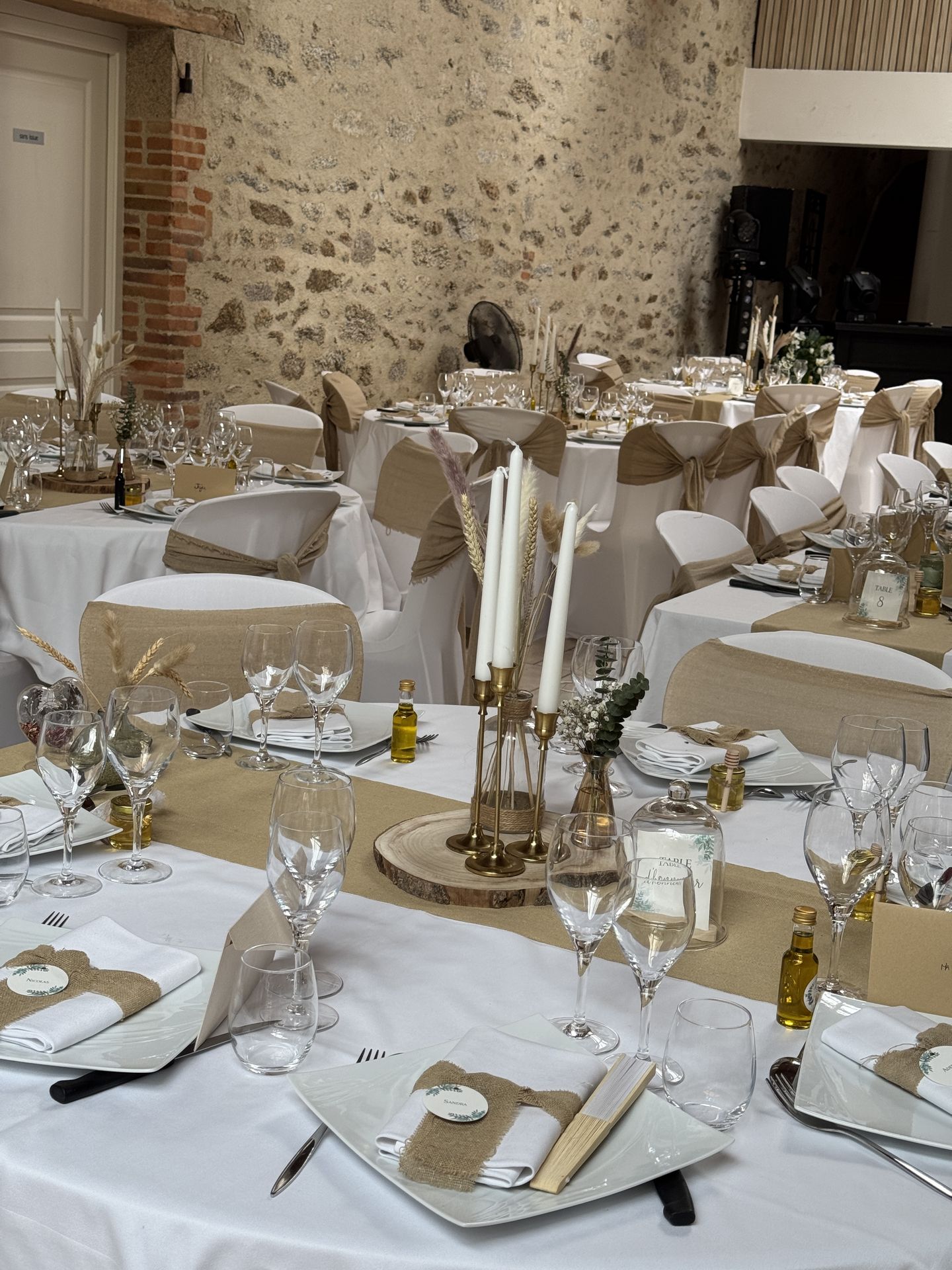 salle intérieur table blanche et sable nœud de chaise rondin de bois bougeoir doré cadeau invités personnalisé