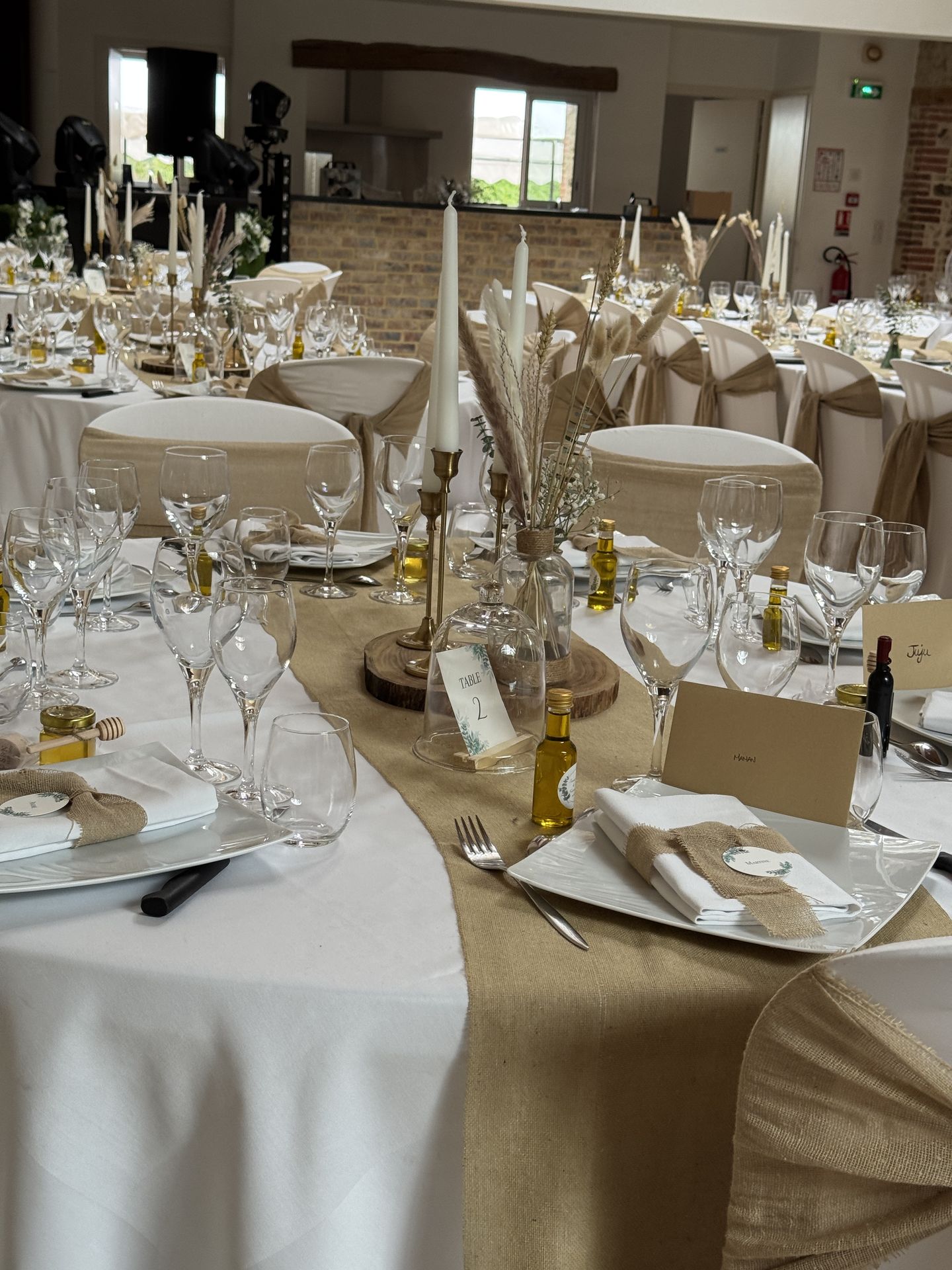 salle intérieur table blanche et sable nœud de chaise rondin de bois bougeoir doré cadeau invités personnalisé