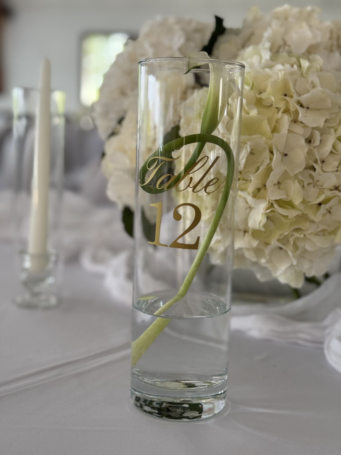 table blanche et composition florale vase transparente bougie nom de table personnalisé