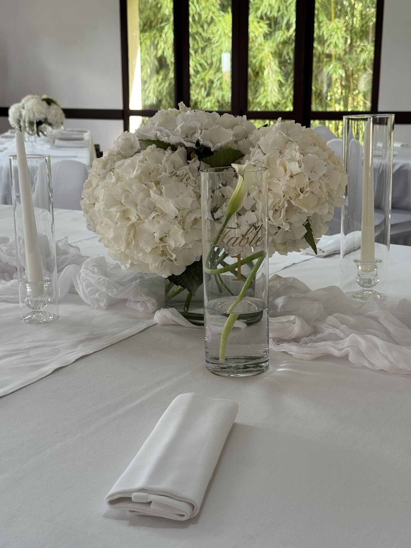 table blanche et composition florale vase transparente bougie nom de table personnalisé