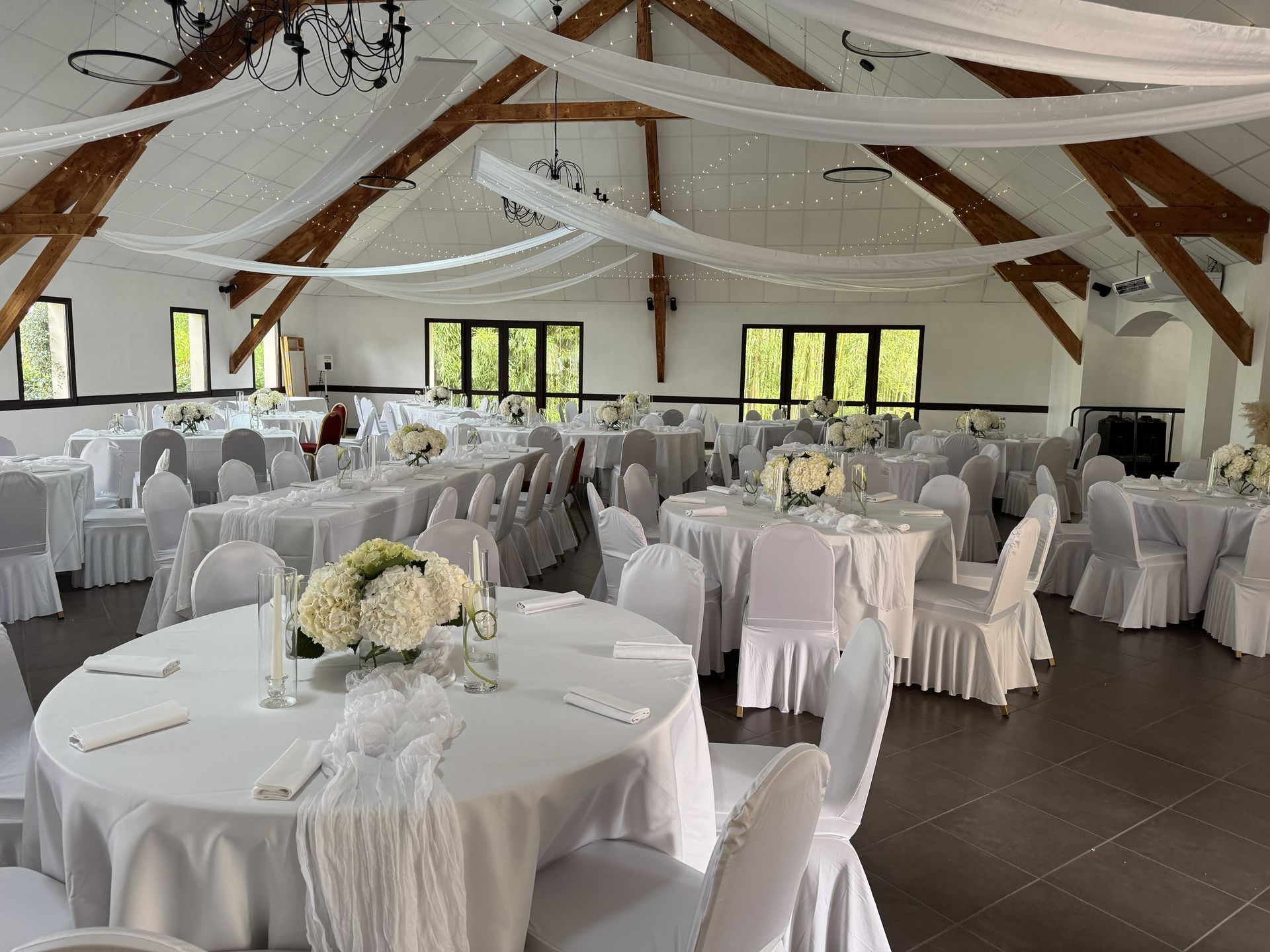 salle intérieur tentures croisés blanches et led lumineuse table blanche et composition florale
