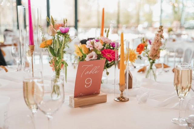 Mariage Domaine de la Sapinière chemin de table blanc compositions florales rose orange et blanche dans des vases transparents bougies de couleurs