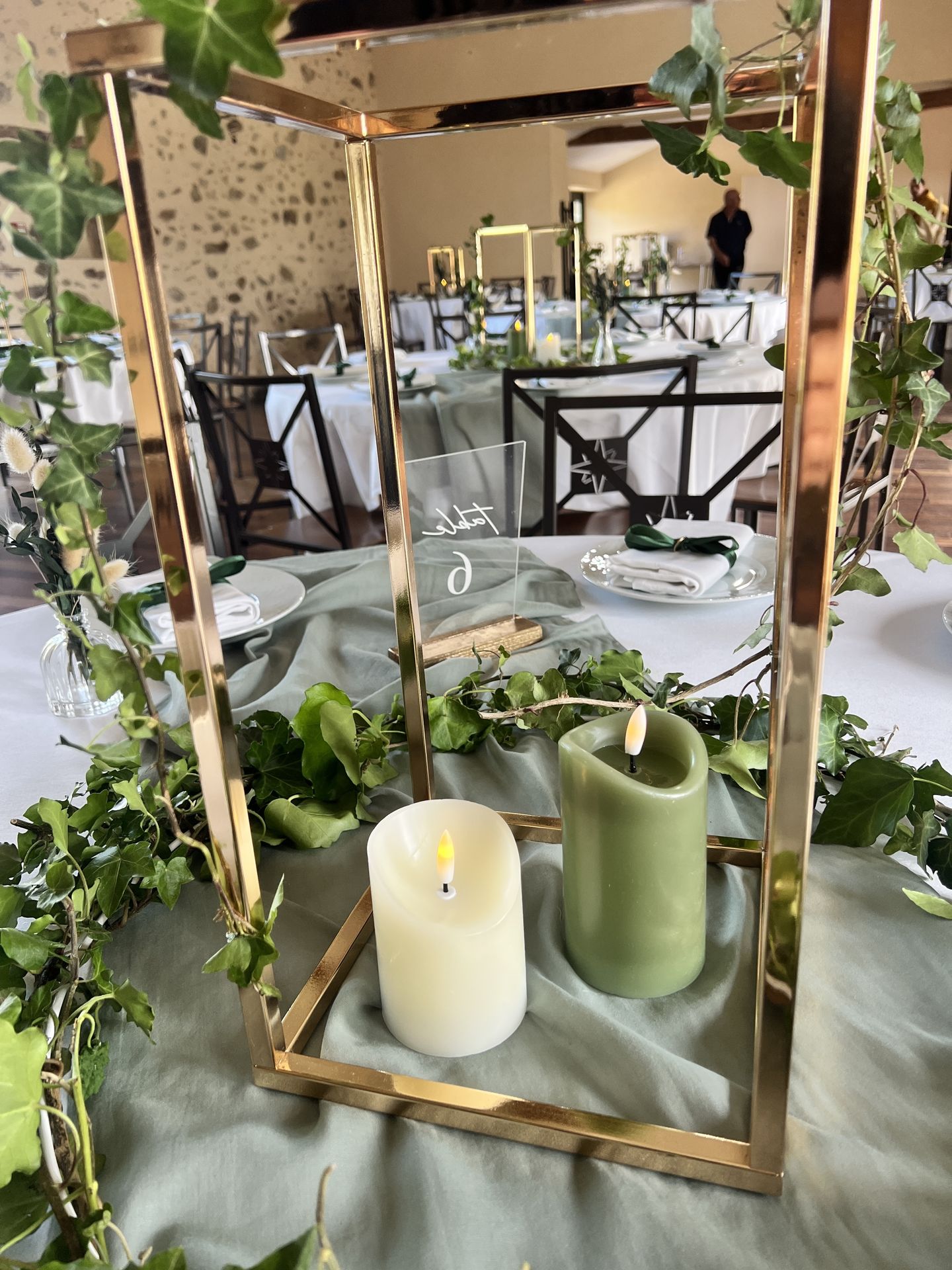 Mariage La belle étoile salle intérieur centre de table cadre doré feuillage bougie verte et blanche nom de table plexis blanc sur socle
