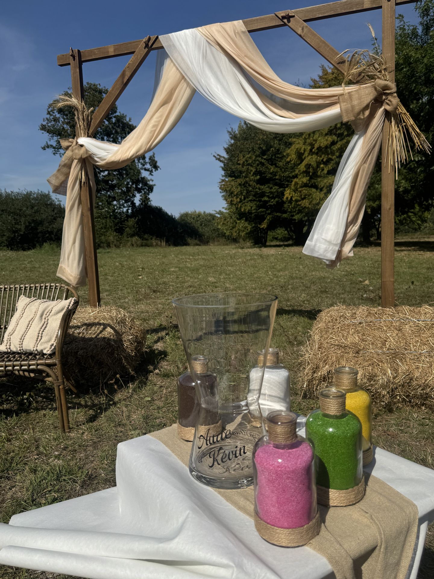 Renouvellement de voeux La pétinière arche tissu blanc et sable épis de blé vase personnalisé et sable de couleurs botte de paille