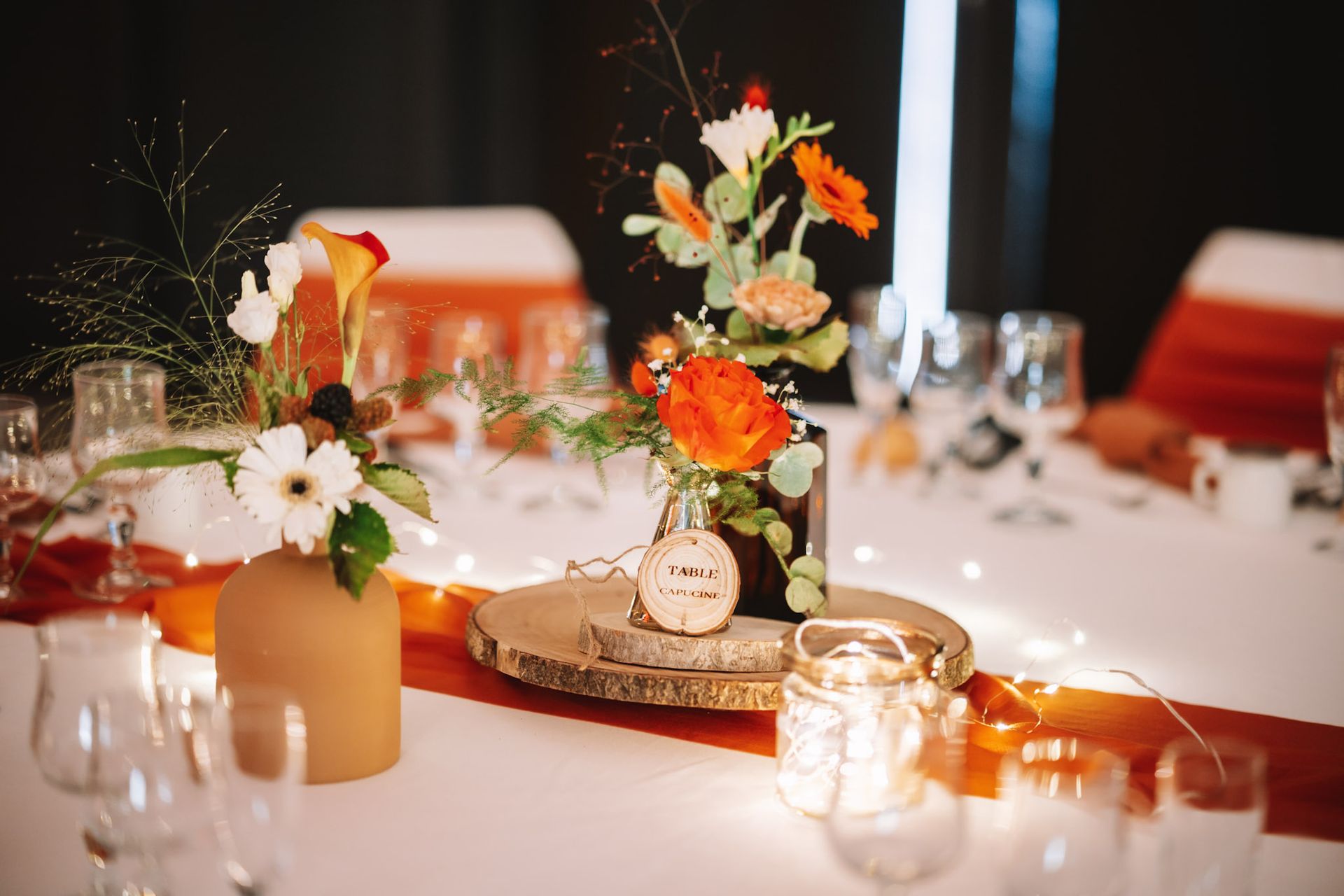 Mariage La Thèvinière table blanches chemin de table terracotta centre de table rondin en bois vase de couleur et feuillage serviette terracotta