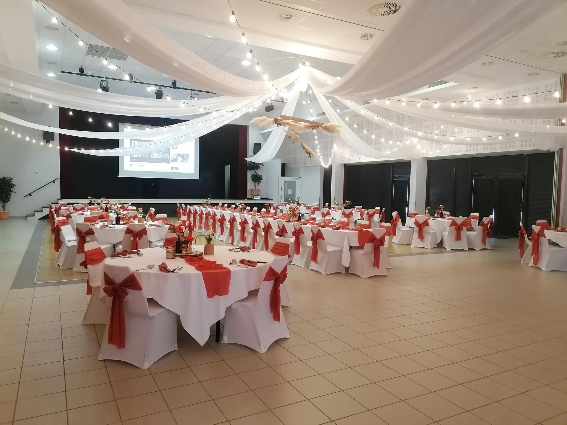 Mariage La Thèvinière plafond tentures blanches leds et structure bois et pampas et salle intérieure table blanche et terracotta