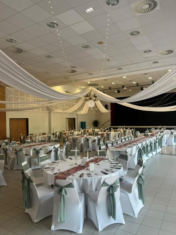 Mariage La Thèvinière tenutres blanches et leds courone de fleurs blanches et roses cercle logo des mariés table blanches noeuds de chaises vert sauges et chemin de table vieux rose