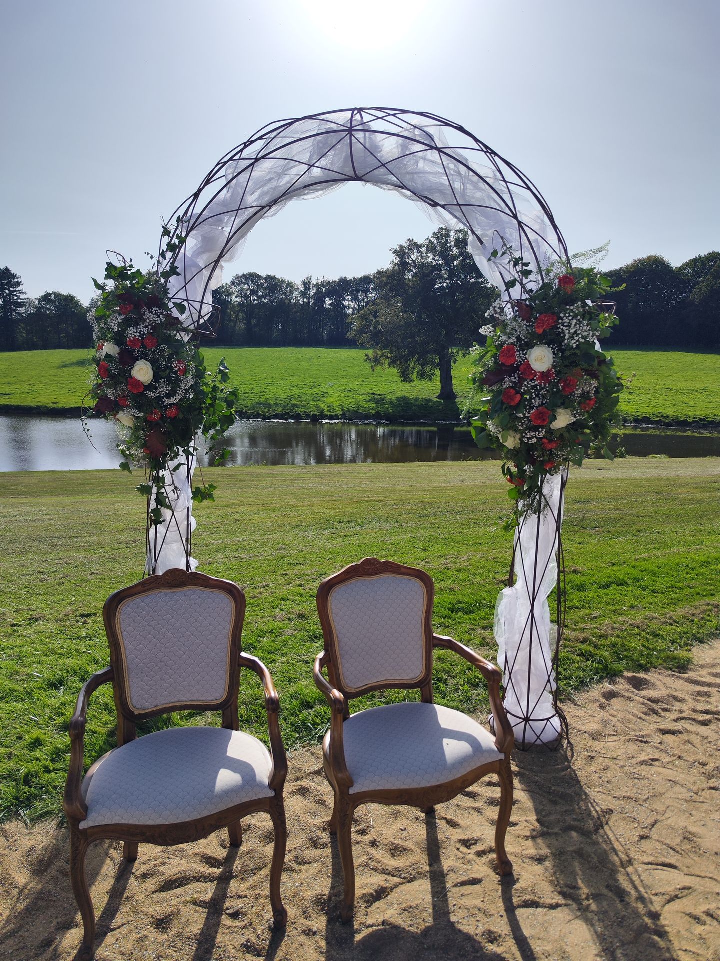 ion Mariage Château de la Bretonnière arche vieille chaises blanche doré fleurs feuillage