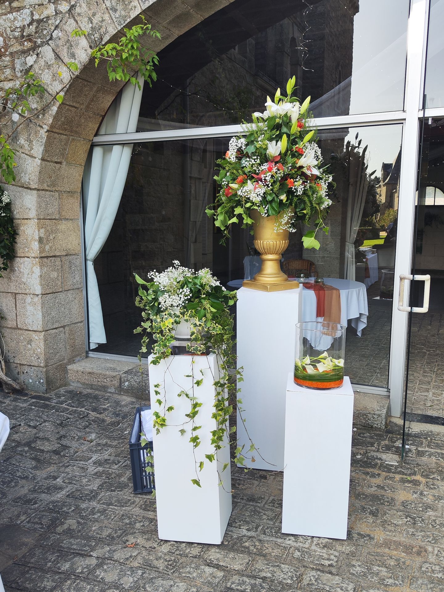 ion Mariage Château de la Bretonnière entrée de salle composition fleurales socle blanc