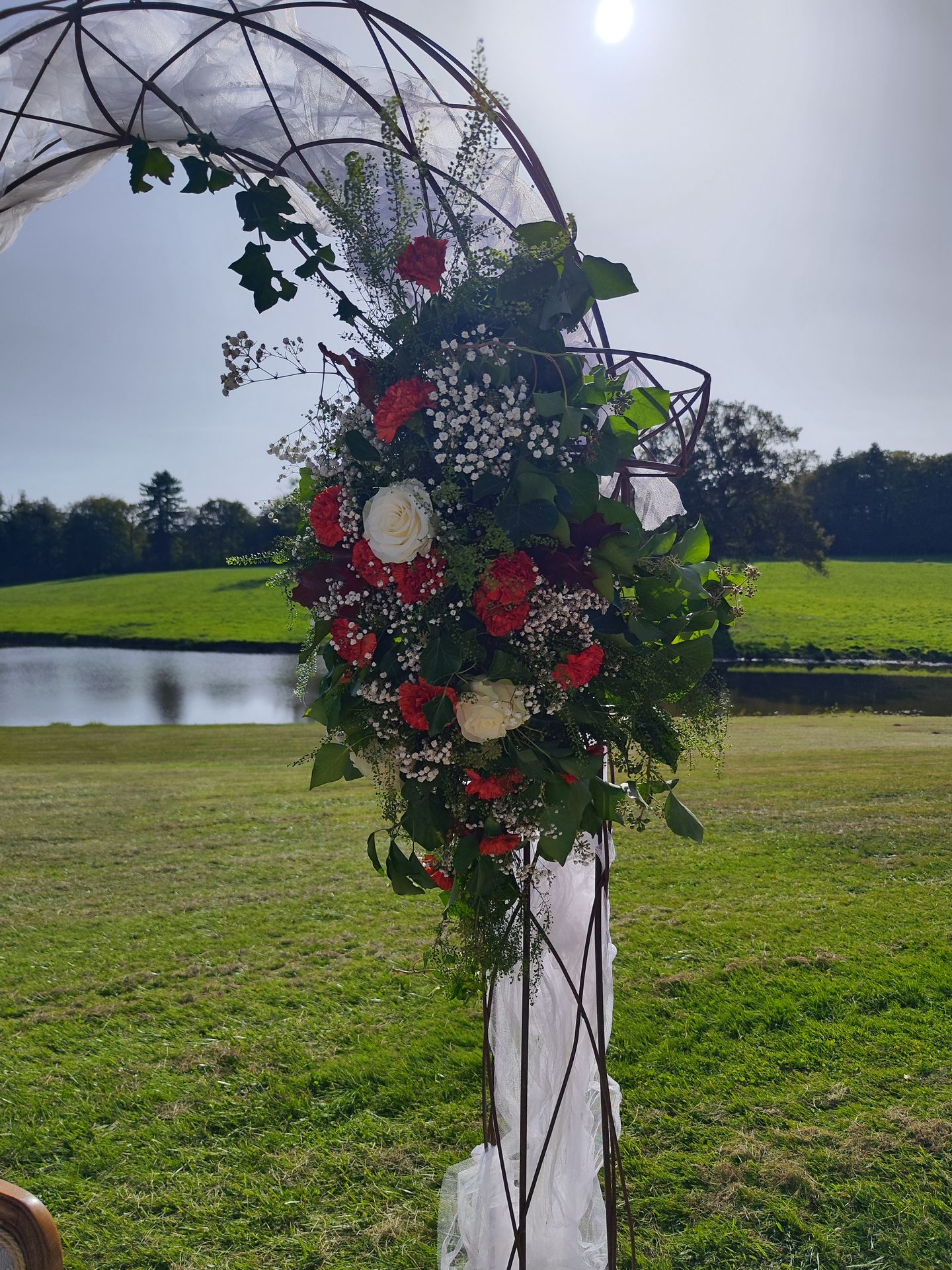 ion Mariage Château de la Bretonnière arche vieille chaises blanche doré fleurs feuillage