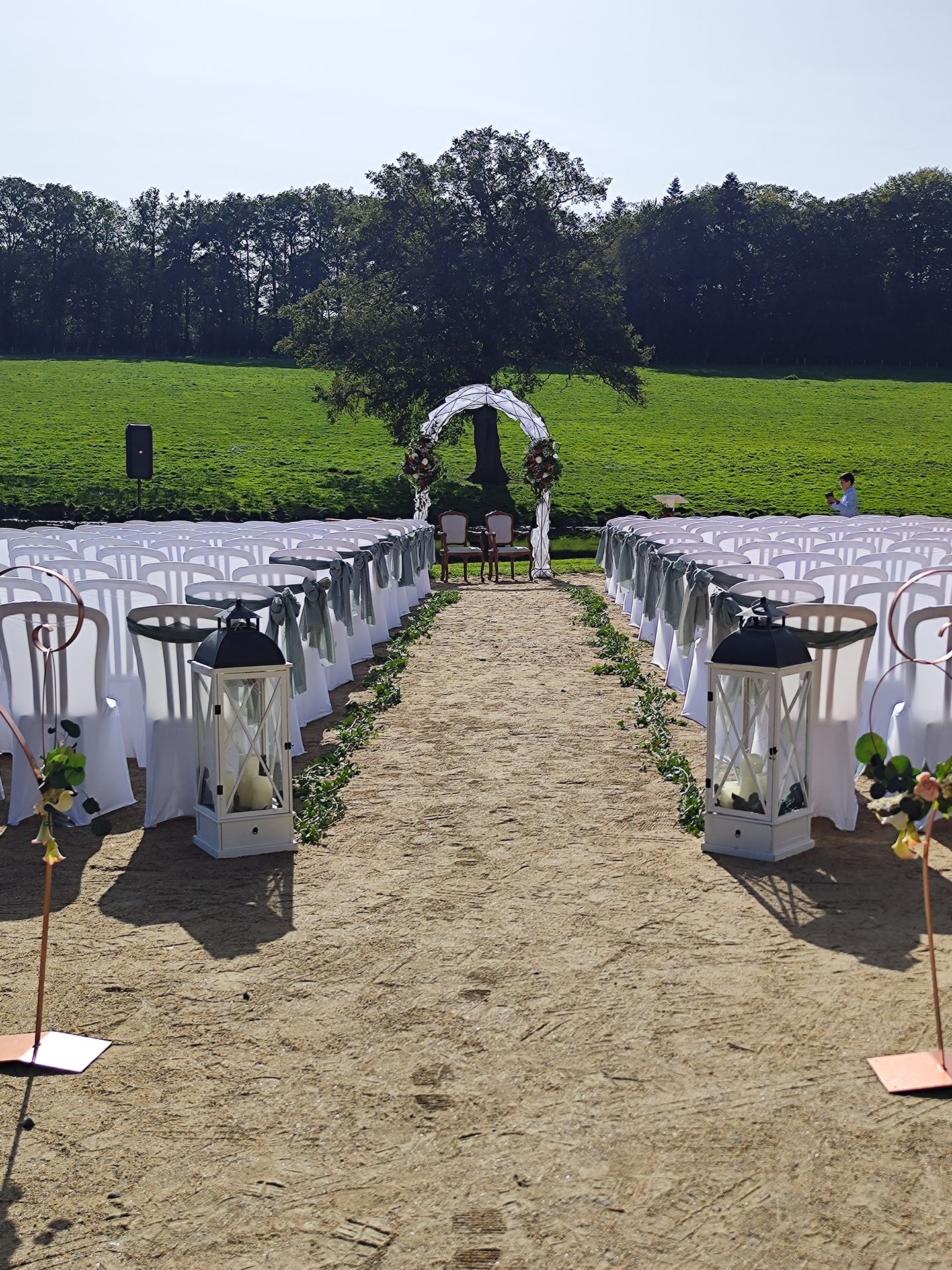 ion Mariage Château de la Bretonnière Cérémonie laique arche blanche et chaises blanches fleuris