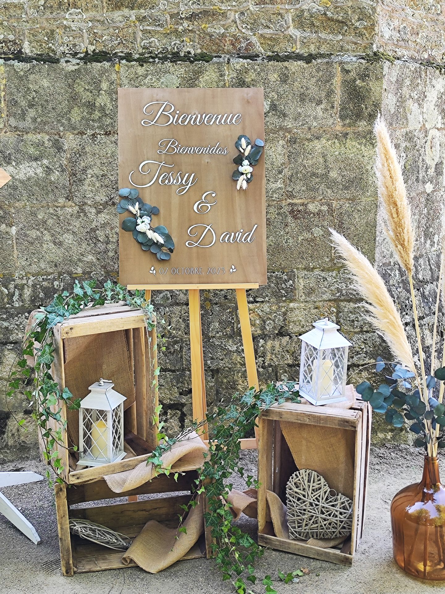 ion Mariage Château de la Bretonnière panneau debinevenue bois et feuillage vert sauge lampes bois caisse pommes