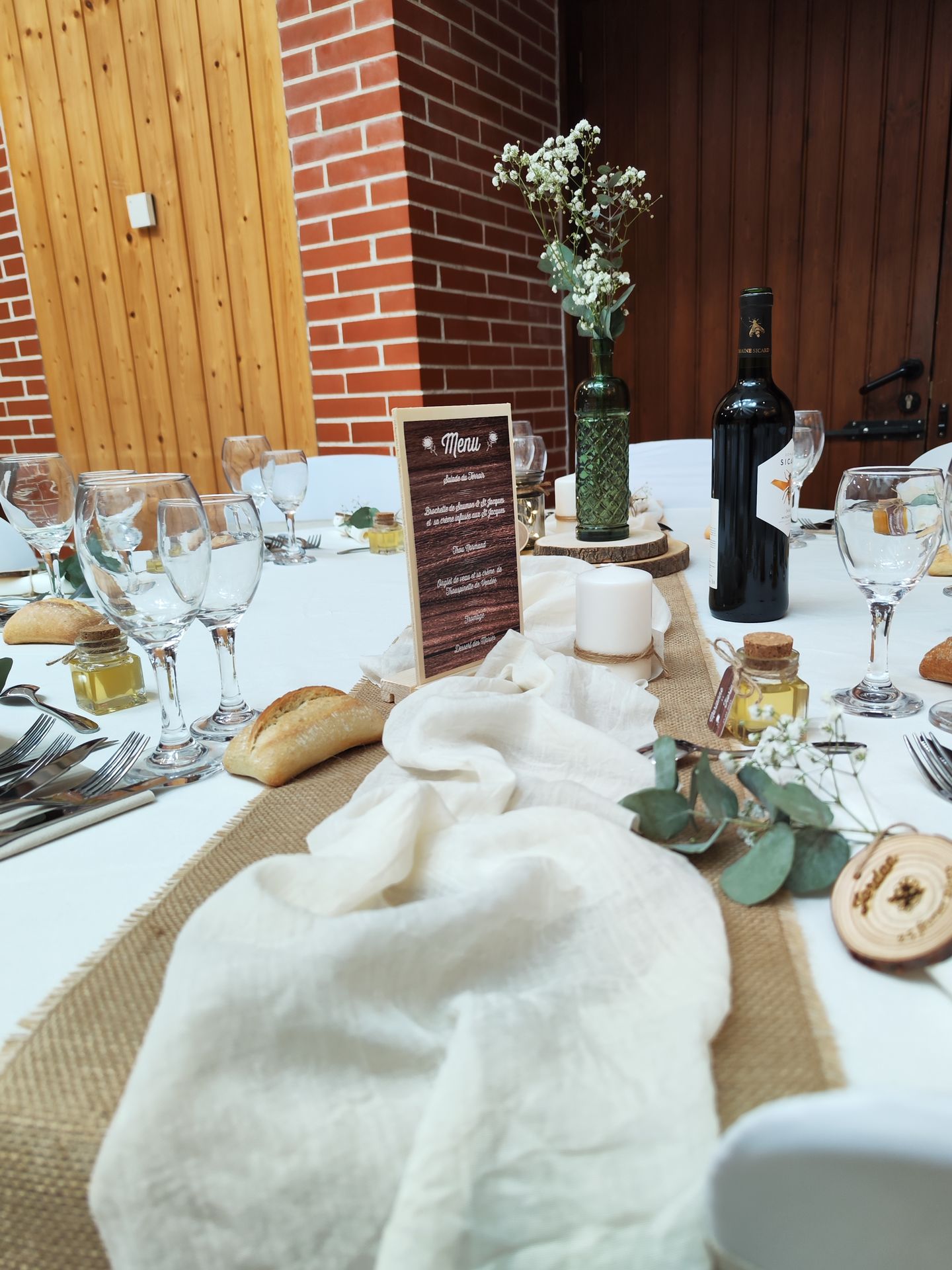 Mariage Domaine des dodais tables blanches noeuds de chaises sables composition florales blanches  et feuillage chemin de table sable et blanc menu en bois centre de table rondin bois et vase de couleur