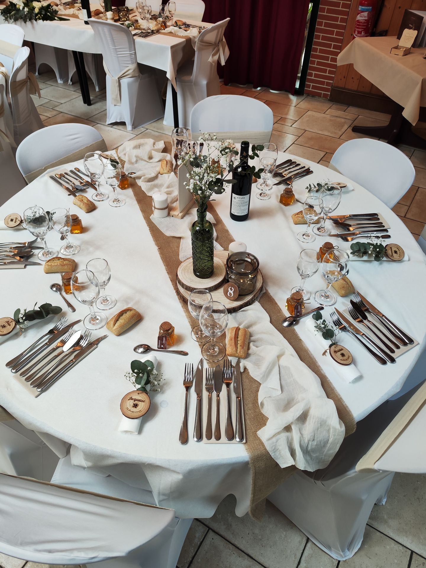 Mariage Domaine des dodais tables blanches noeuds de chaises sables composition florales blanches  et feuillage cehmin de table sable et blanc centre de table rondin bois et vase de couleur