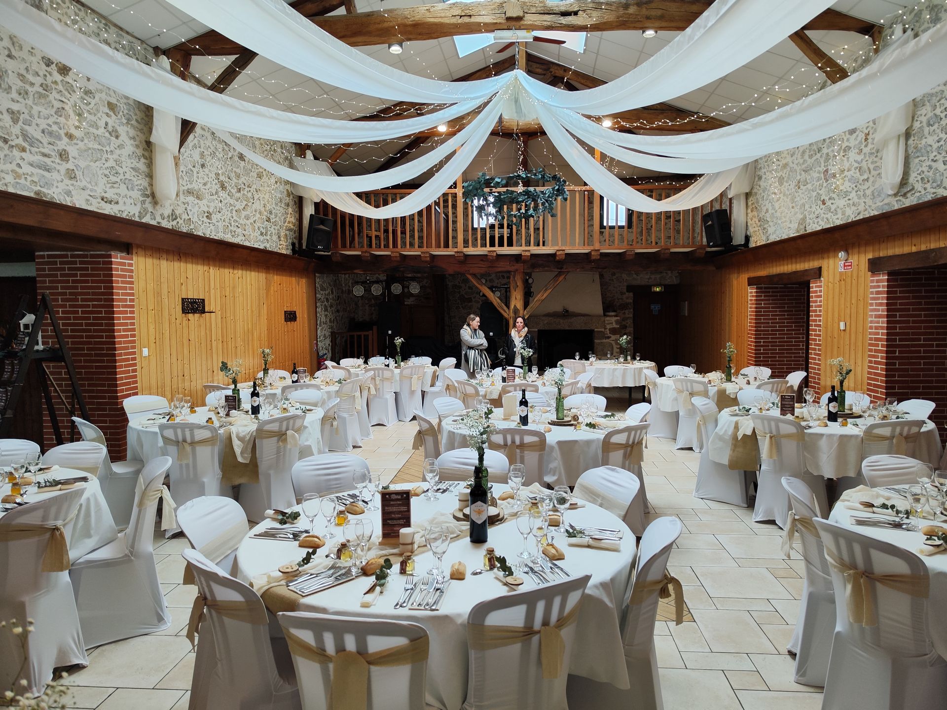 Mariage Domaine des dodais plafond tentures blanches et couronne de feuillage et leds table blanches noueds de chaises sables