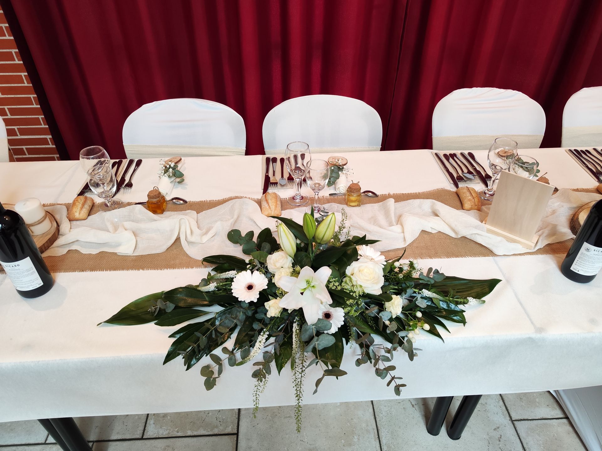 Mariage Domaine des dodais tables blanches noeuds de chaises sables composition florales blanches  et feuillage cehmin de table sable et blanc