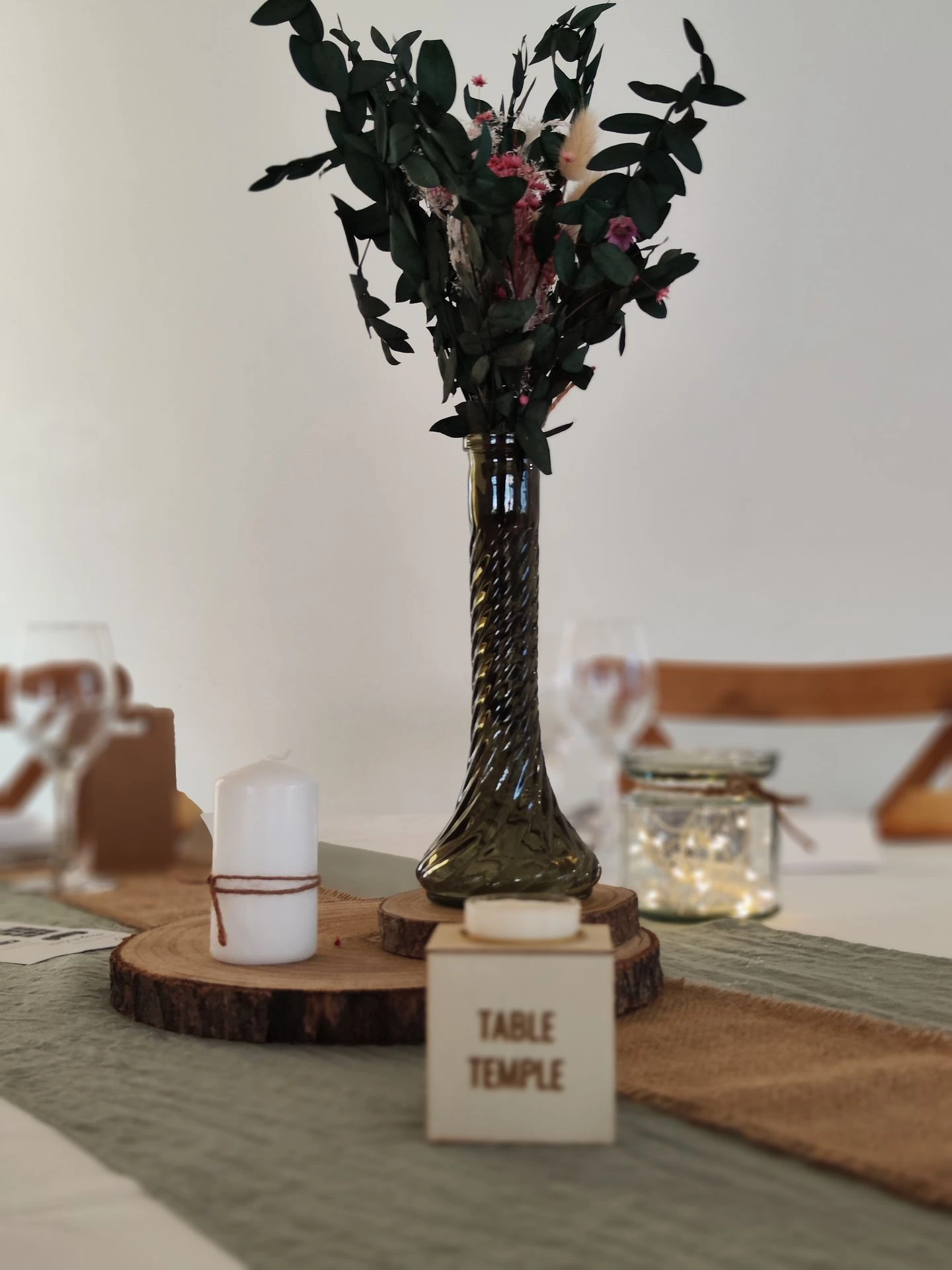 Mariage Domaine 4 Plumes chemin de table vert sauge rondin en bois et vase vert feuillage bougies