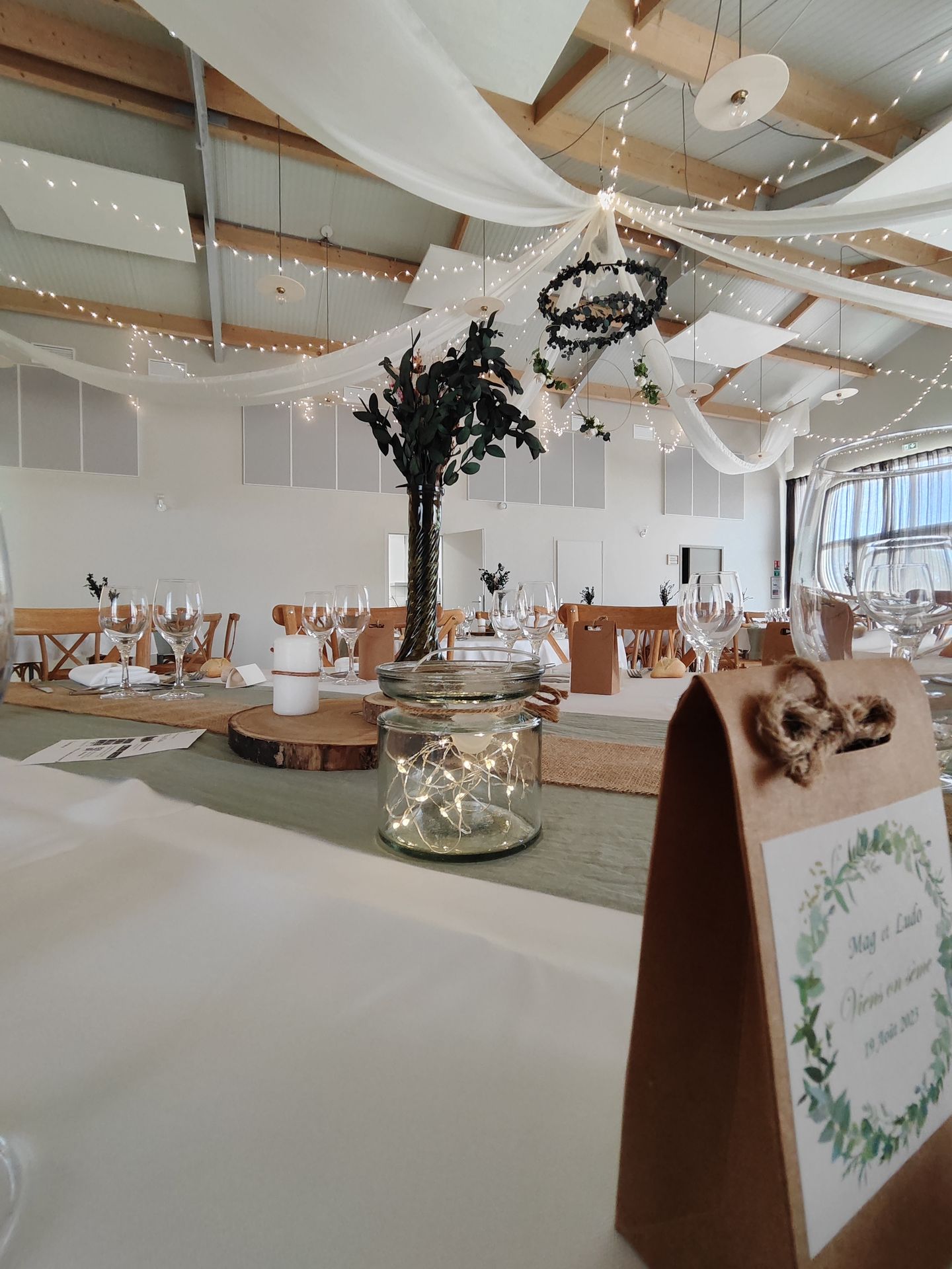 Mariage Domaine 4 Plumes chemin de table vert sauge rondin en bois bois et vase vert feuillage packaging cadeaux invités