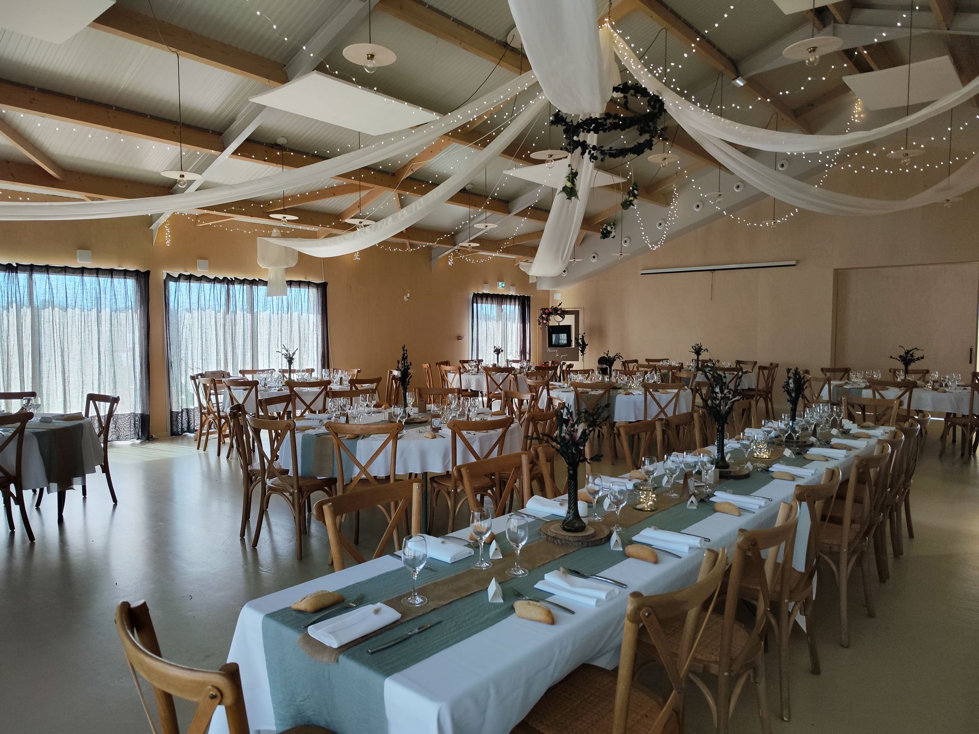 Mariage Domaine 4 Plumes plafond tentures leds et couronne de feuillage tables blanches et chemin vert sauge bois