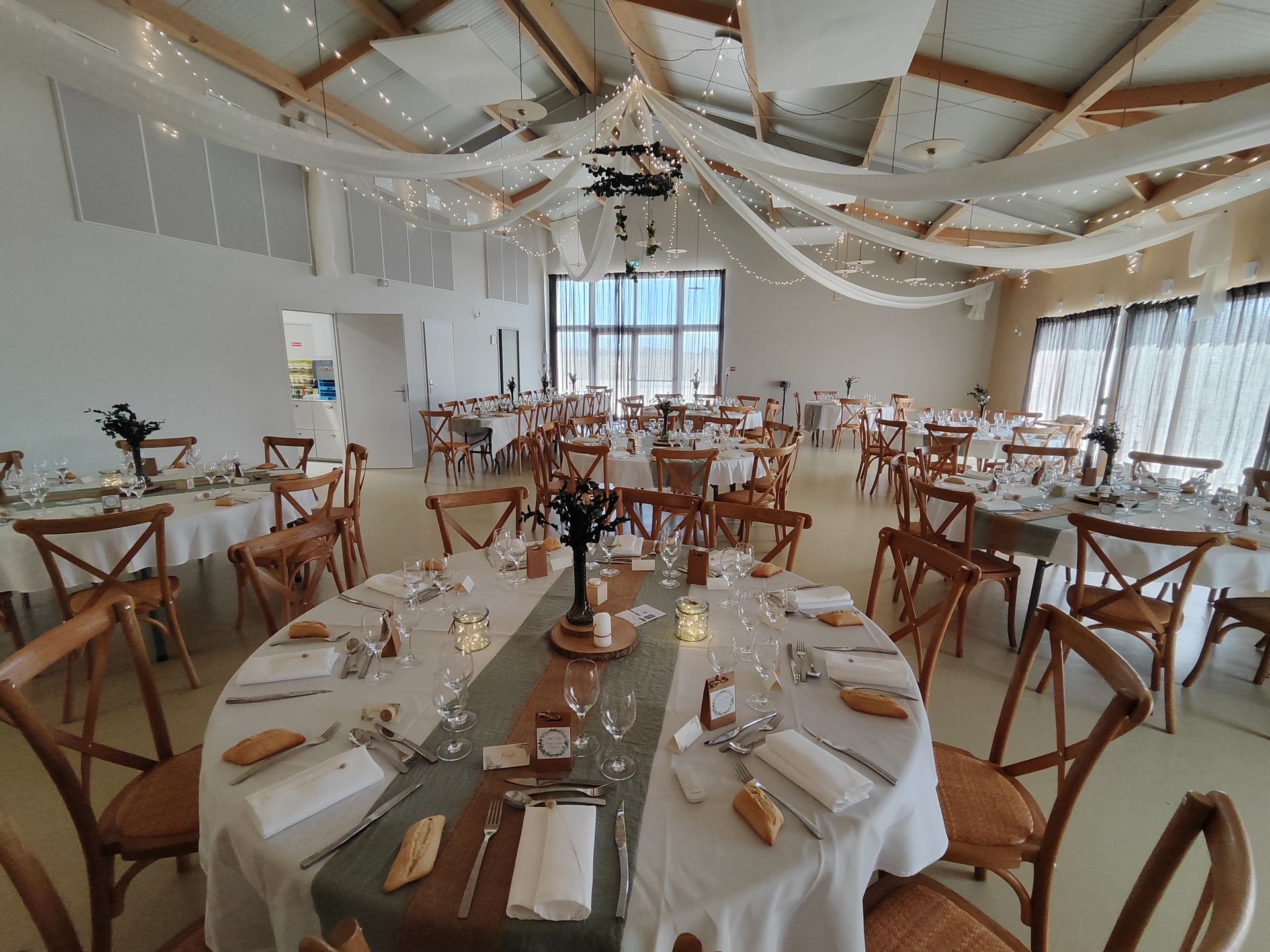 Mariage Domaine 4 Plumes plafond tentures leds et couronne de feuillage tables blanches et chemin vert sauge bois