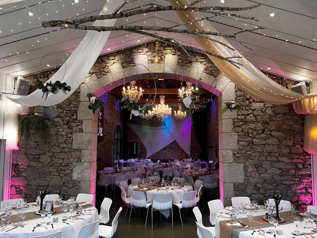 Mariage La Vallée de la roche salle intérieure plafond tentures blanches et sables et bois arbre tables blanches et chemins de table naturel