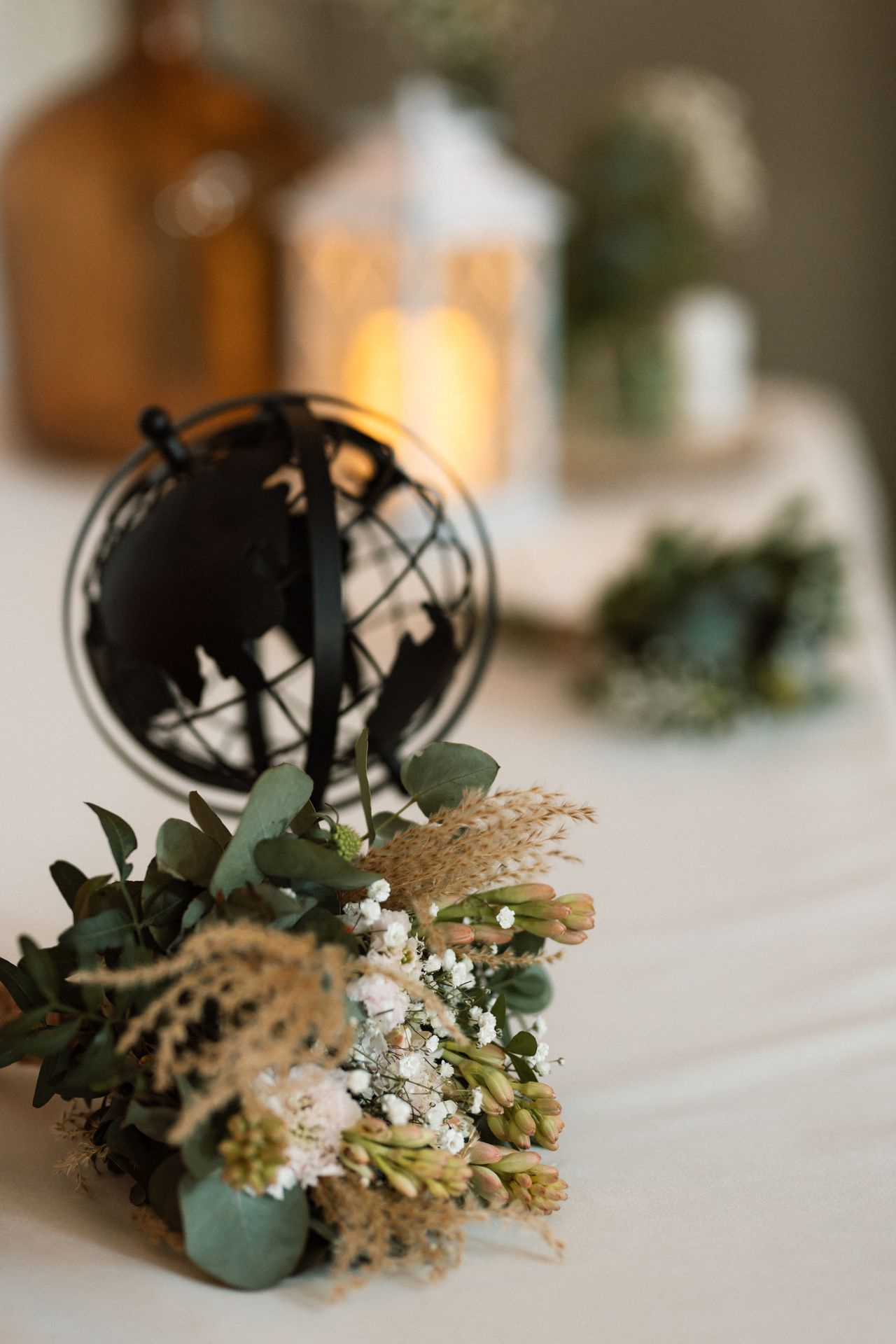 Mariage Salle de la Goubaudière salle intérieure tables blanches compositions flroales verte et blanches et globale terrestre noir