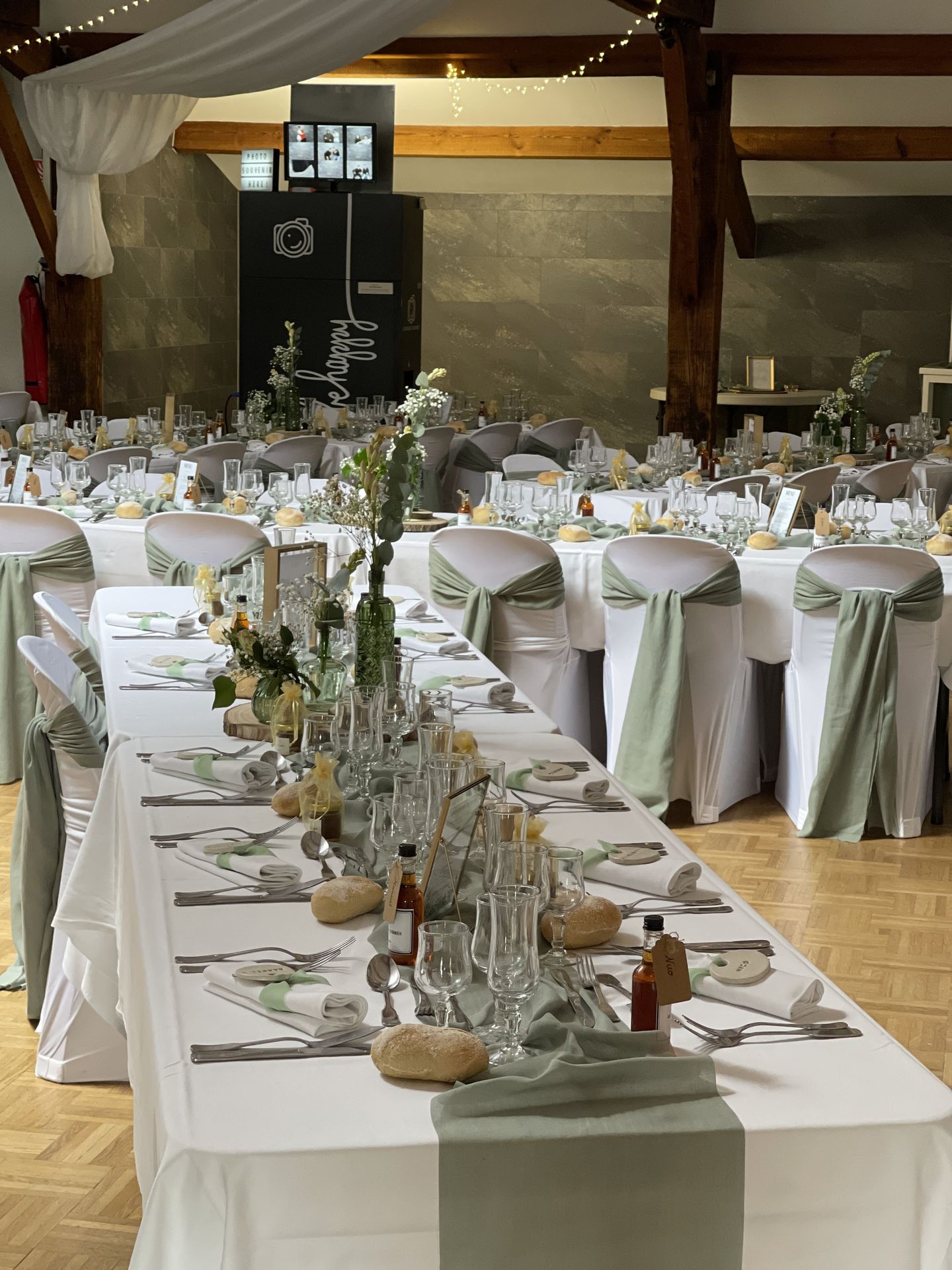 Mariage Salle de la Goubaudière salle intérieure tables blanches noeuds de chaises tentures blanches leds
