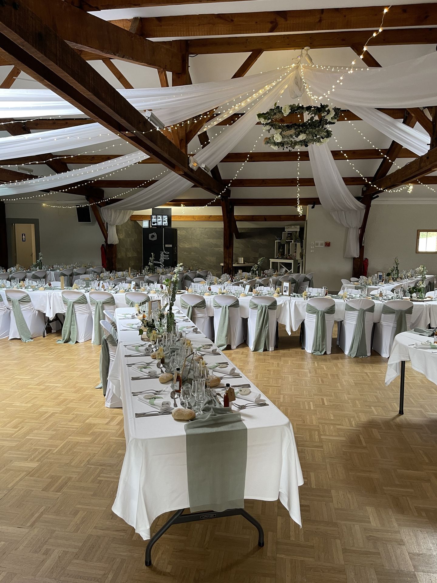 Mariage Salle de la Goubaudière salle intérieure tables blanches noeuds de chaises tentures blanches leds