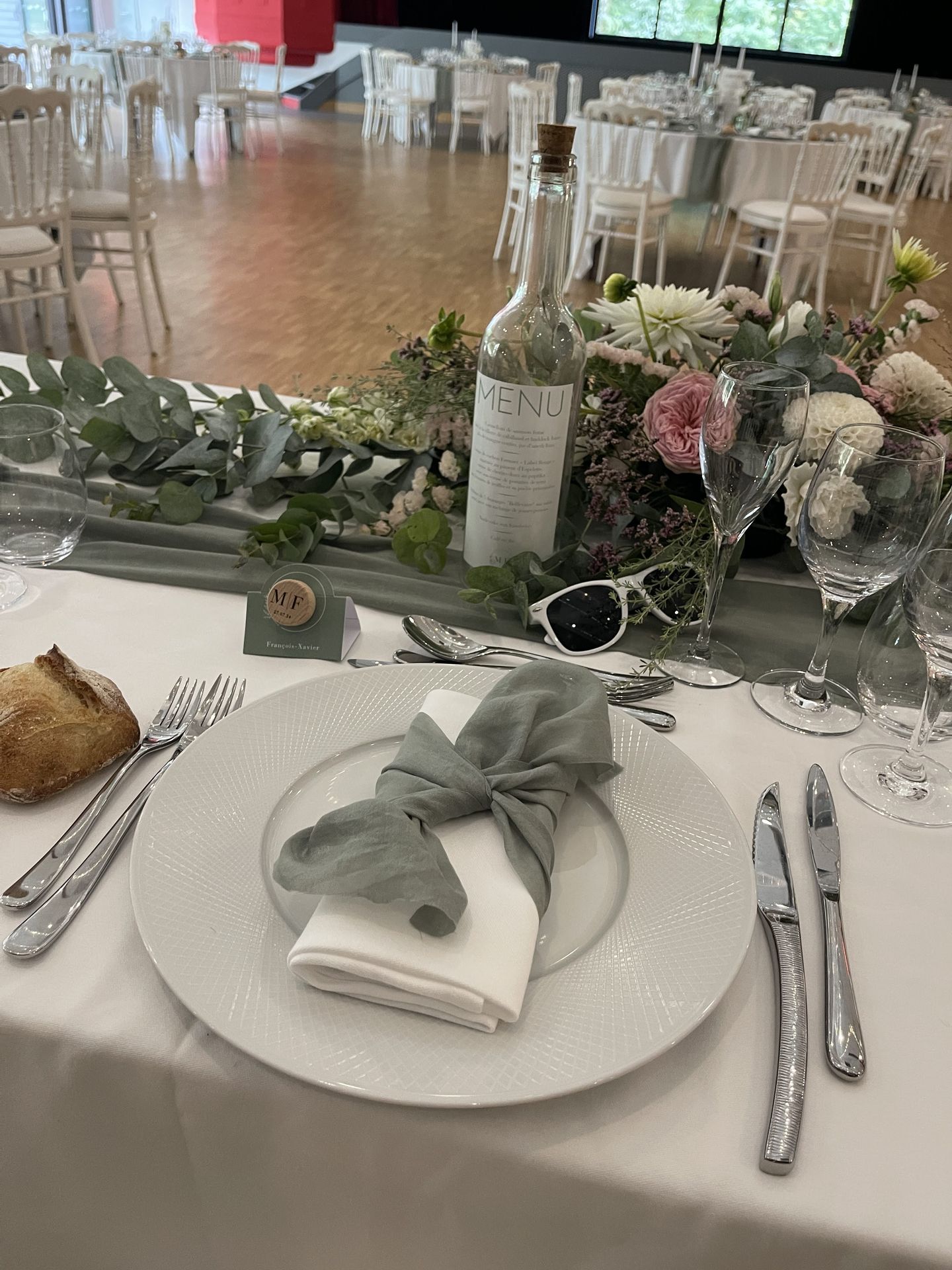 Mariage les Landebaudières table blanche chemin de table vert sauge serviette blanche et noeud vert sauge composition florales bouteille en verre