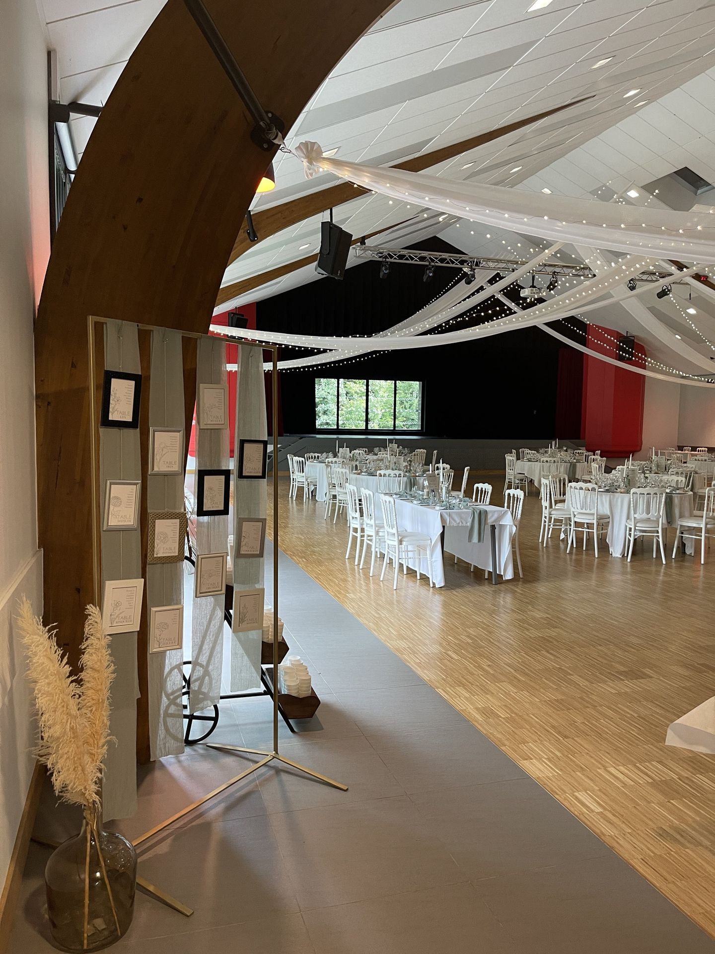 Mariage les Landebaudières salle intérieure plan de table cadre doré argent blanc et noir vase pampas table blanc