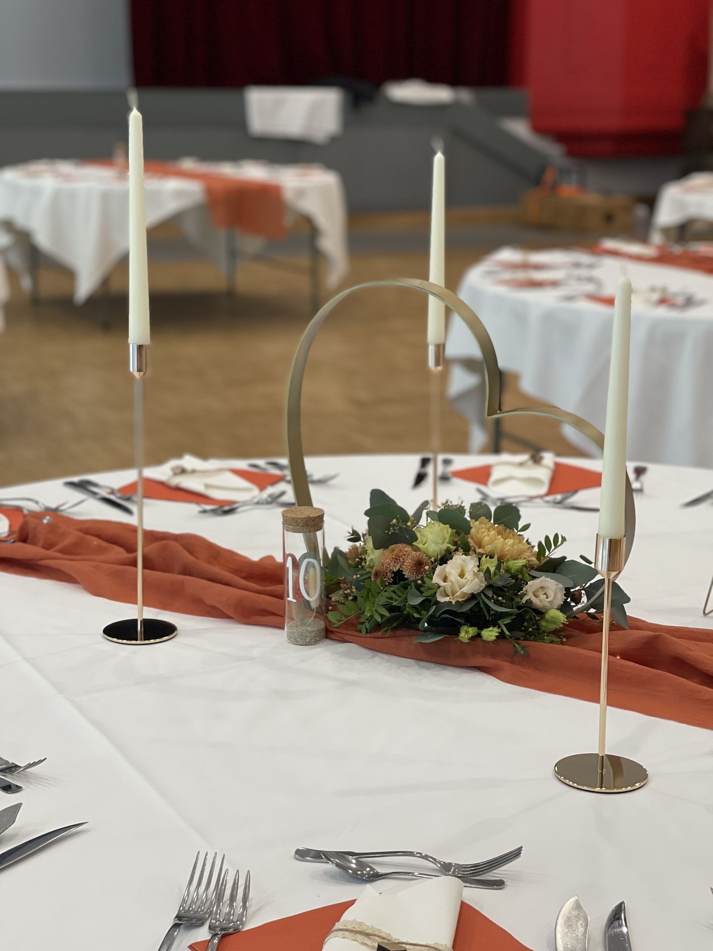 Mariage Salle Les Landebaudières plafond tentures et leds tables blanches structure coeur doré compositions florales eprouvette nom de table bougies beige