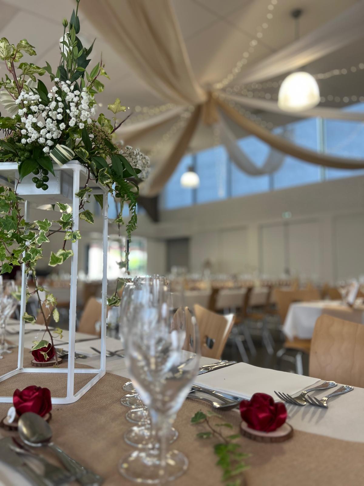 Mariage Espace Renaudin table blanchs chemin de table sable marque place avec rose rouge composition feuillage vert sur structure blanche
