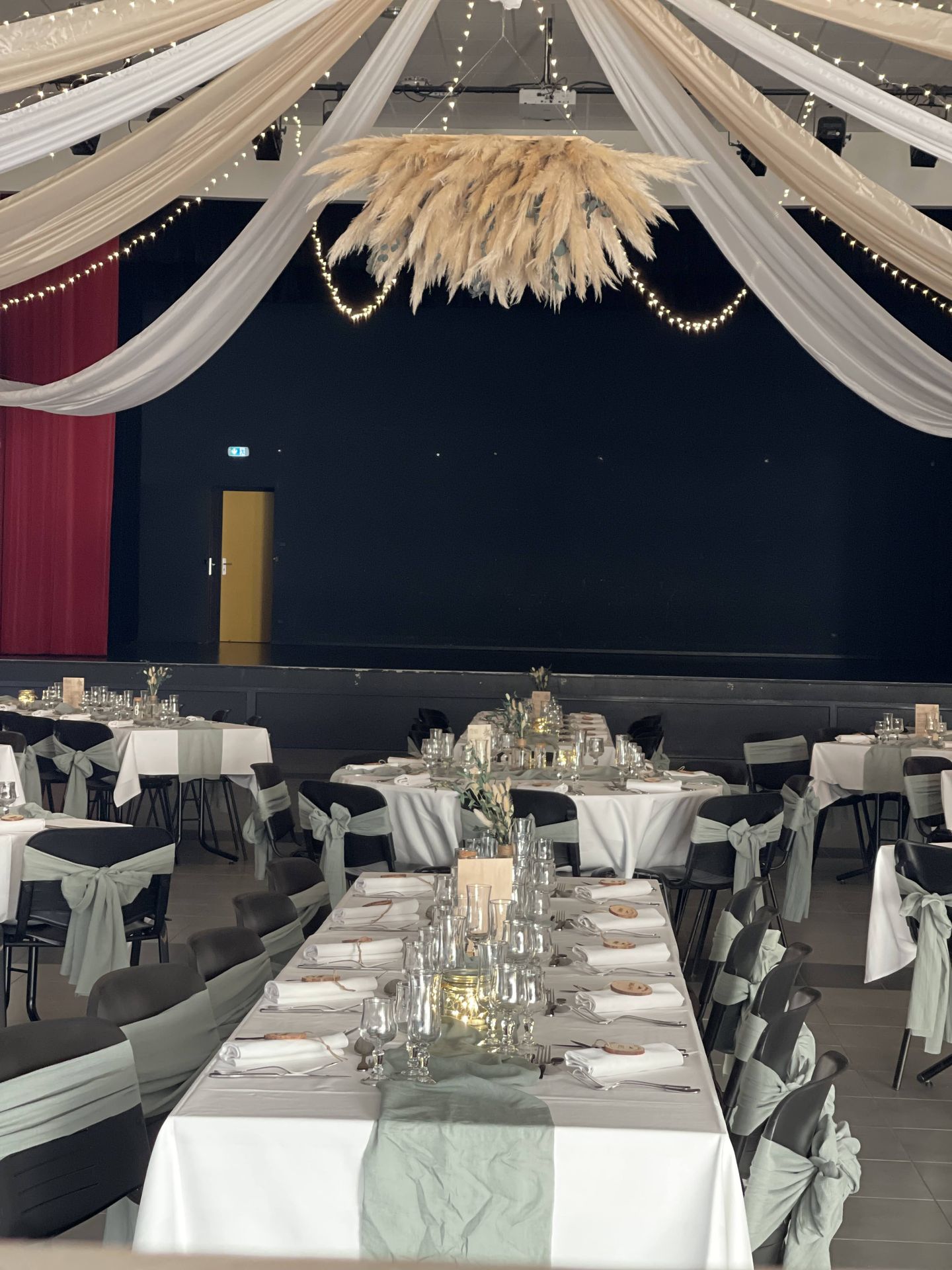 Mariage Espace Galerne plafond tentures sables blanches et leds boules de pampas table blanche chemin vert sauge noeud de chaise vert sauge