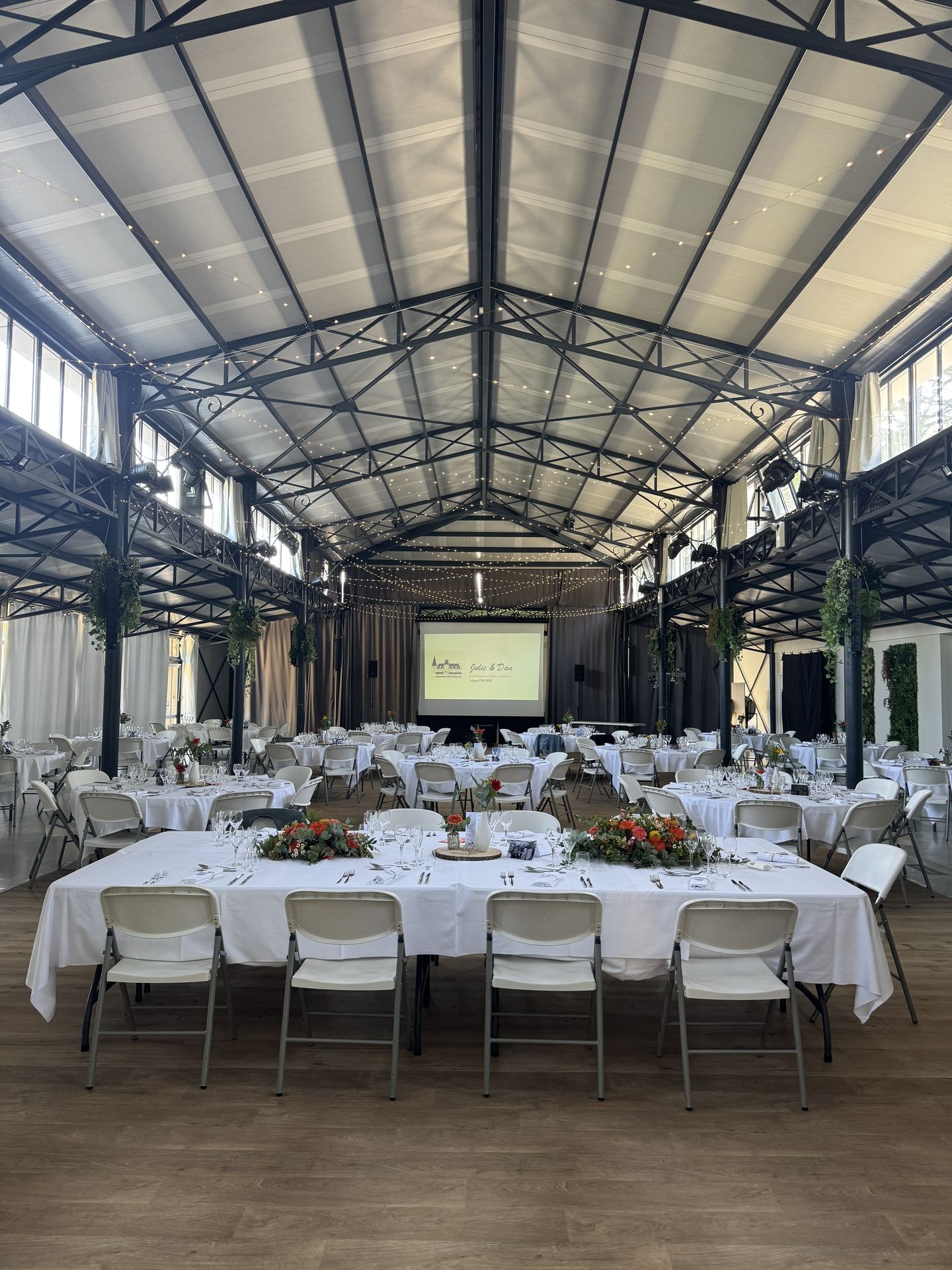 Mariage la Barbinière salle intérieur ciel étoilé table blanche composition florales coloré