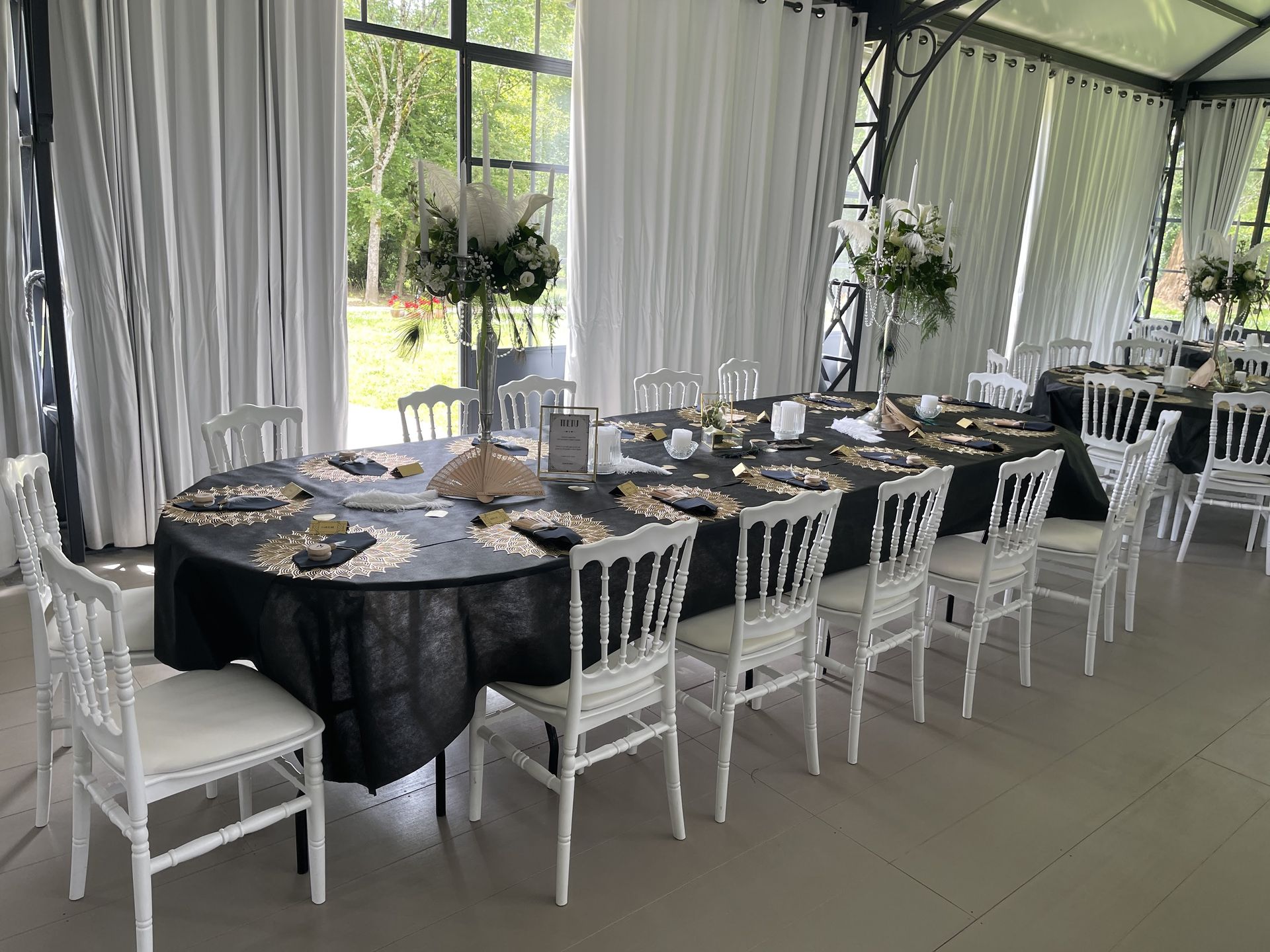 Mariage La Frogerie salle intérieure nappe noir chaises napoléon blanchegrande compositions florales hauteur