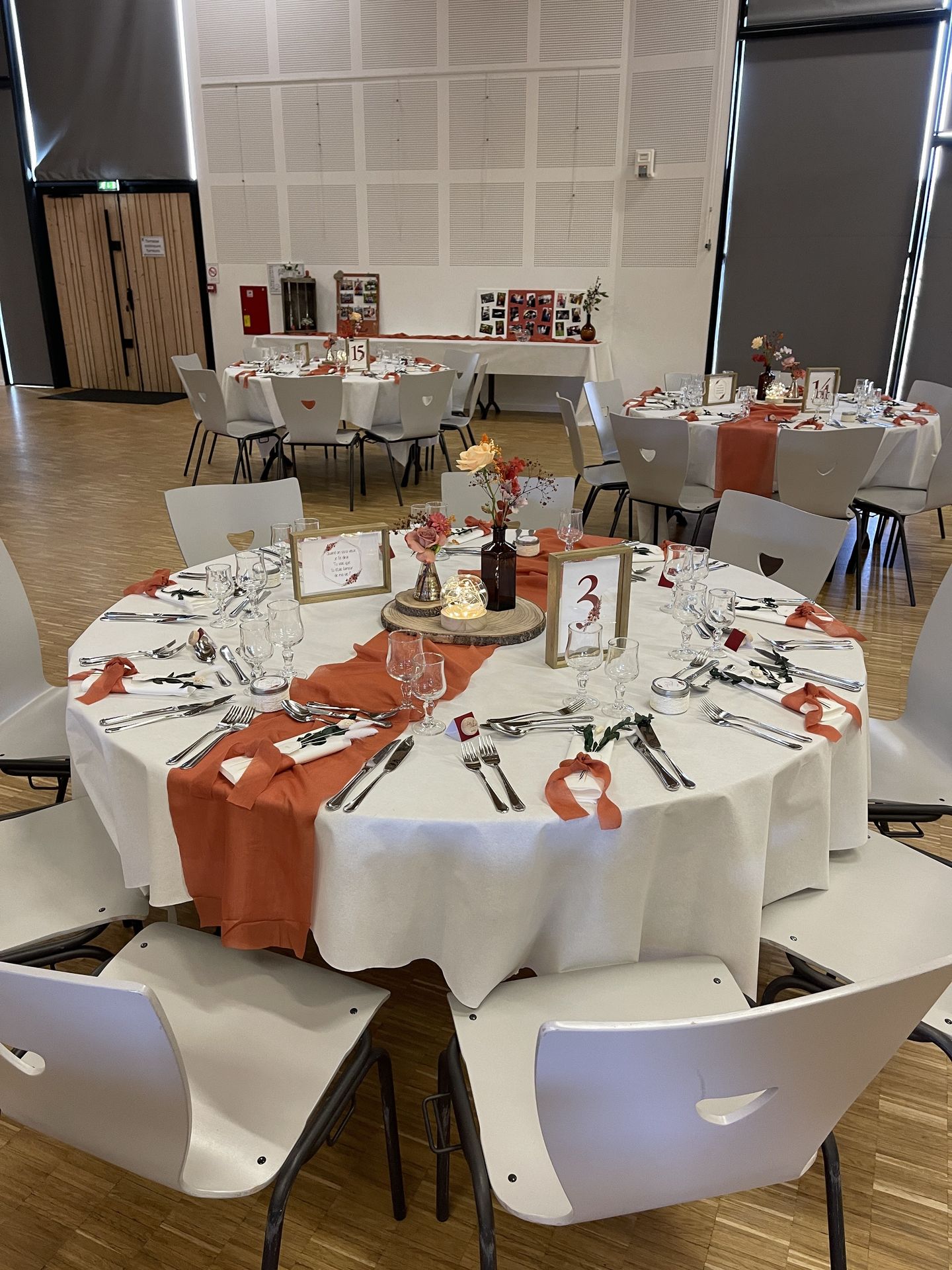 Mariage La Prairie table blanche chemin de table terracotta menu cadre en bois centre de table rondin en bois vase leds fleurs terracotta