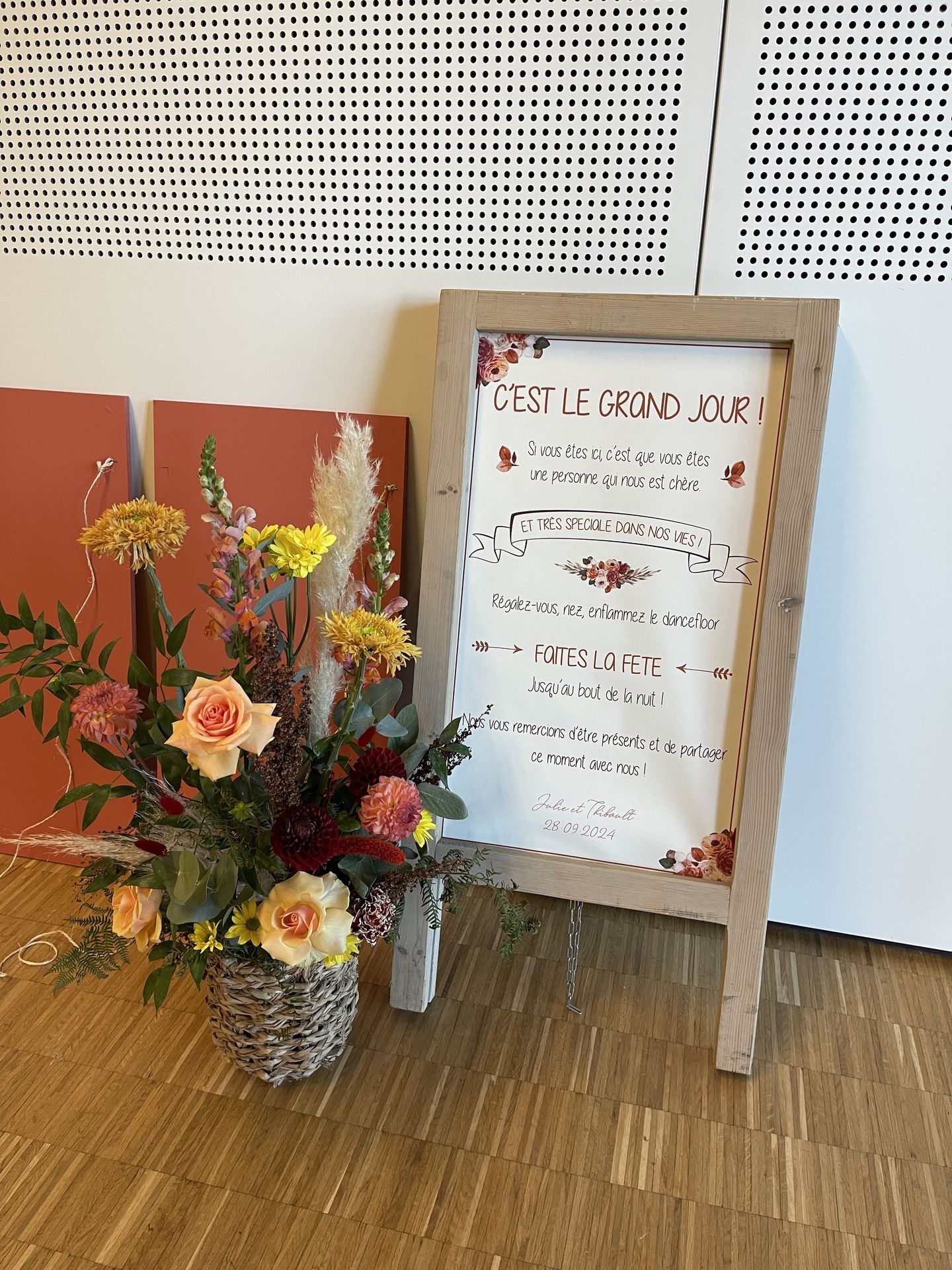 Mariage La Prairie grande composition florales message de bienvenue en bois terracotta