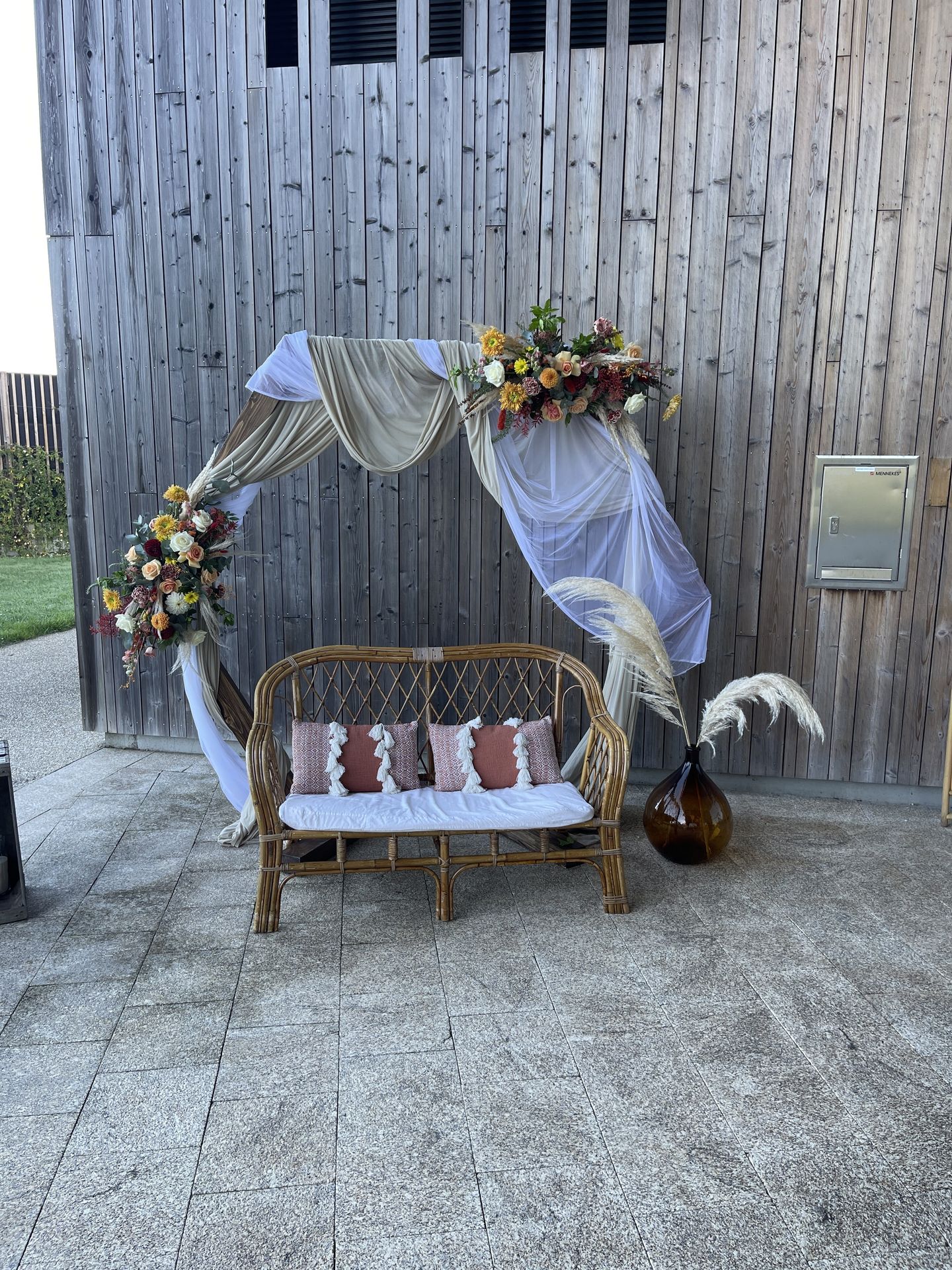 Mariage La Prairie cérémonie laique arche tissu blanc et sable composition florales canapé bois