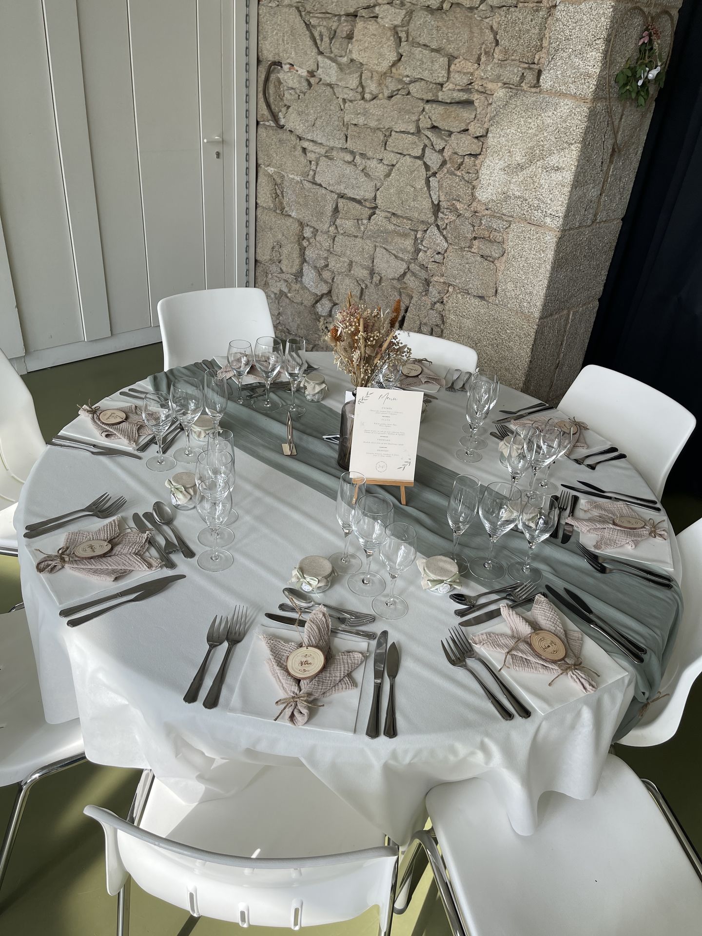 Mariage Vallée de la Roche table blanches et chemin de table vert sauge serviette sable marque place rondin en bois vase fleurs sèches menu en bois