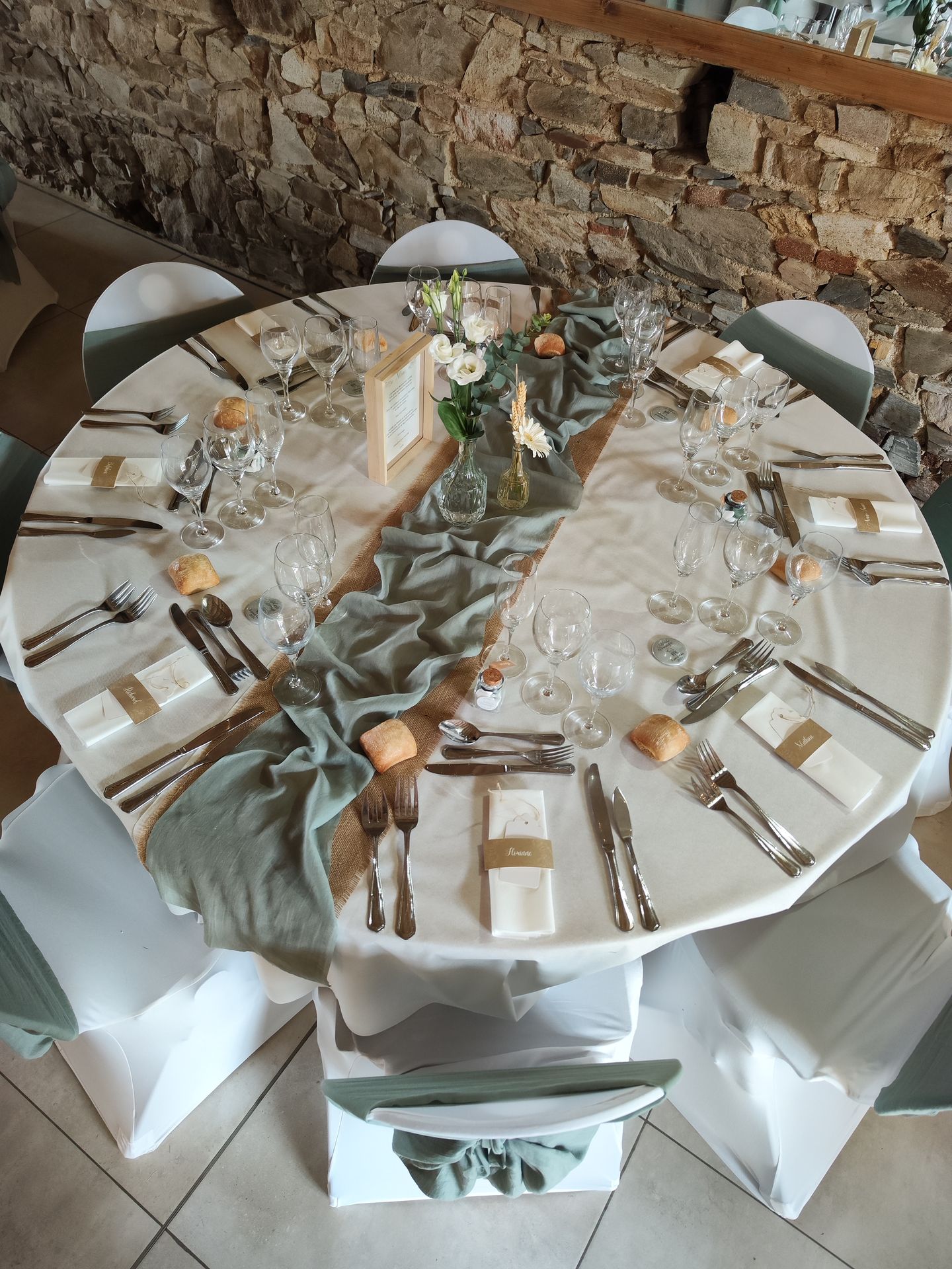 Mariage Domaine de Marin table blanche chemin de table sable et vert sauge noeud de chaise cadrebois naturel vase composition florales