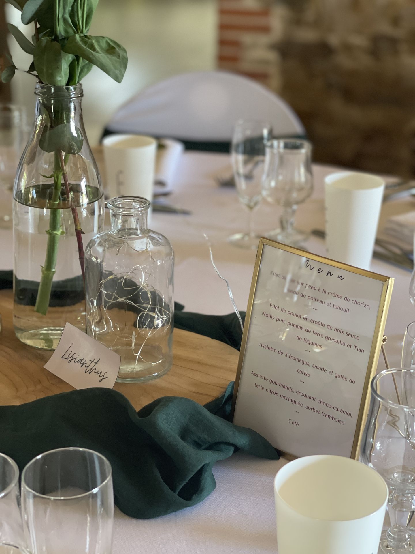 Mariage Domaine de Marin centre de table tissu vert sapin rondin en bois vase fleurs cadre dorée menu de tabl