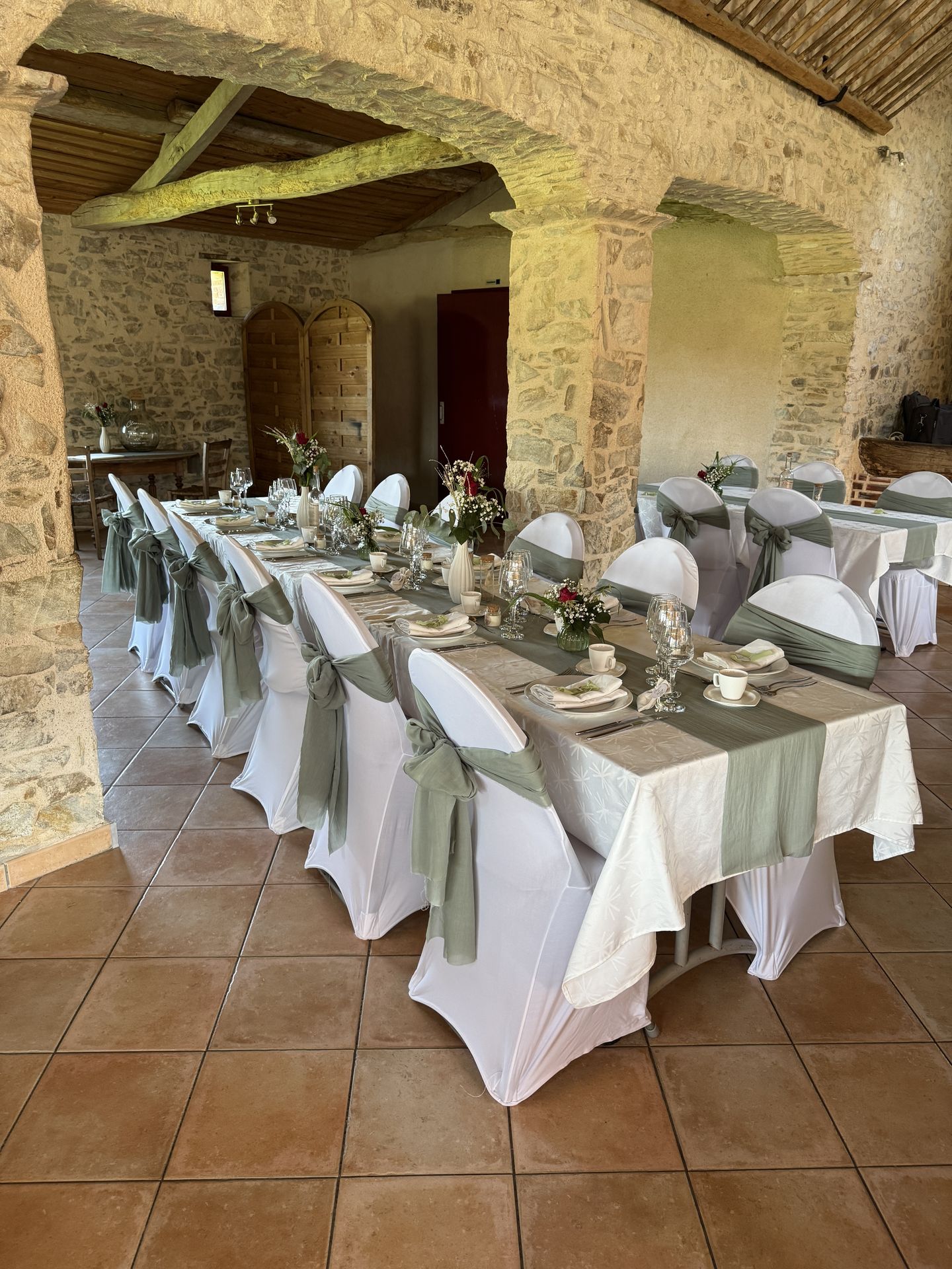 Mariage La Chaumerie table blanche et noeud vert sauge fleurs en vase