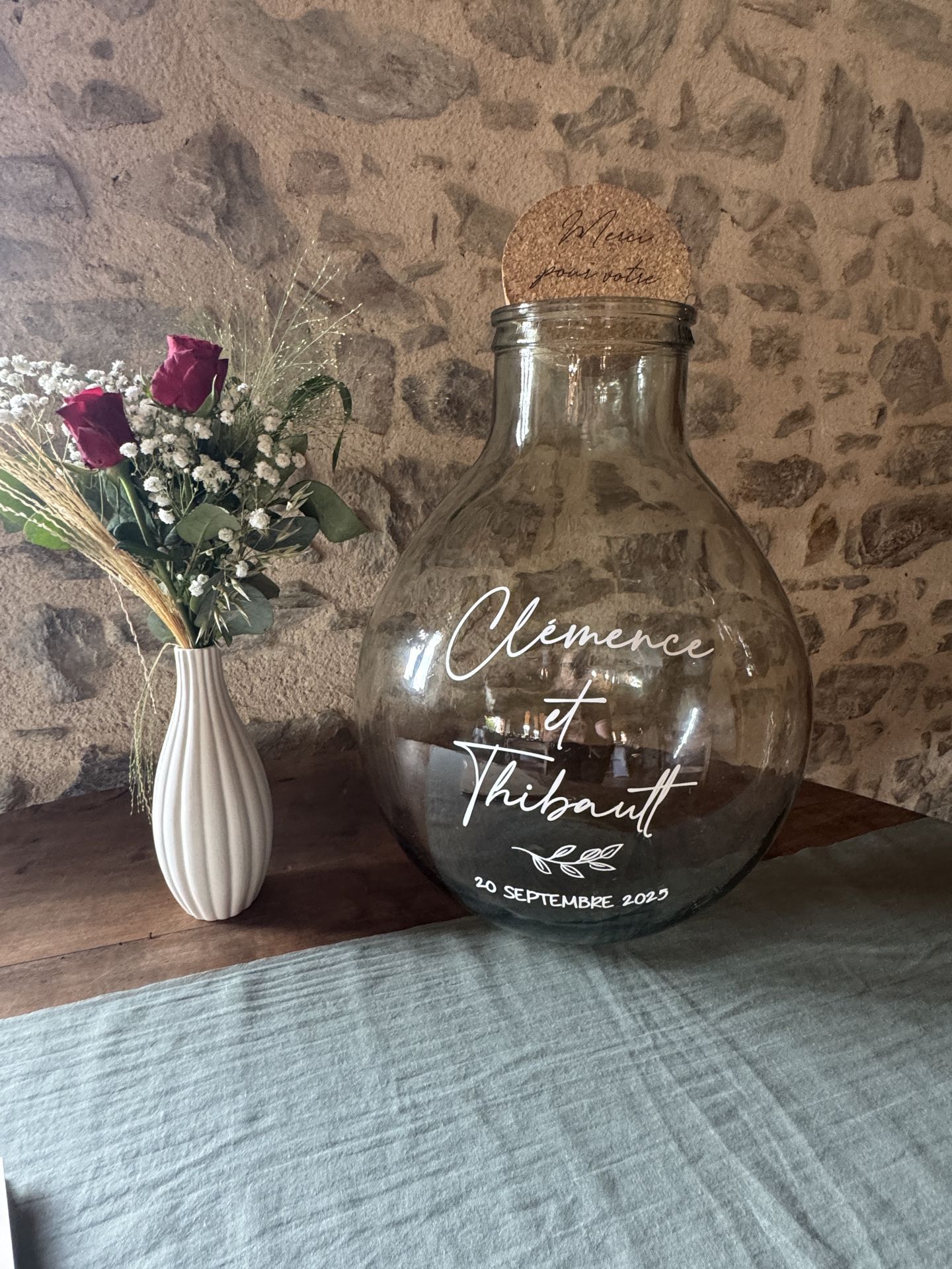 Mariage La Chaumerie cagnotte dame-jeanne personnalisé et vase blanc fleurs rouge et végétaux